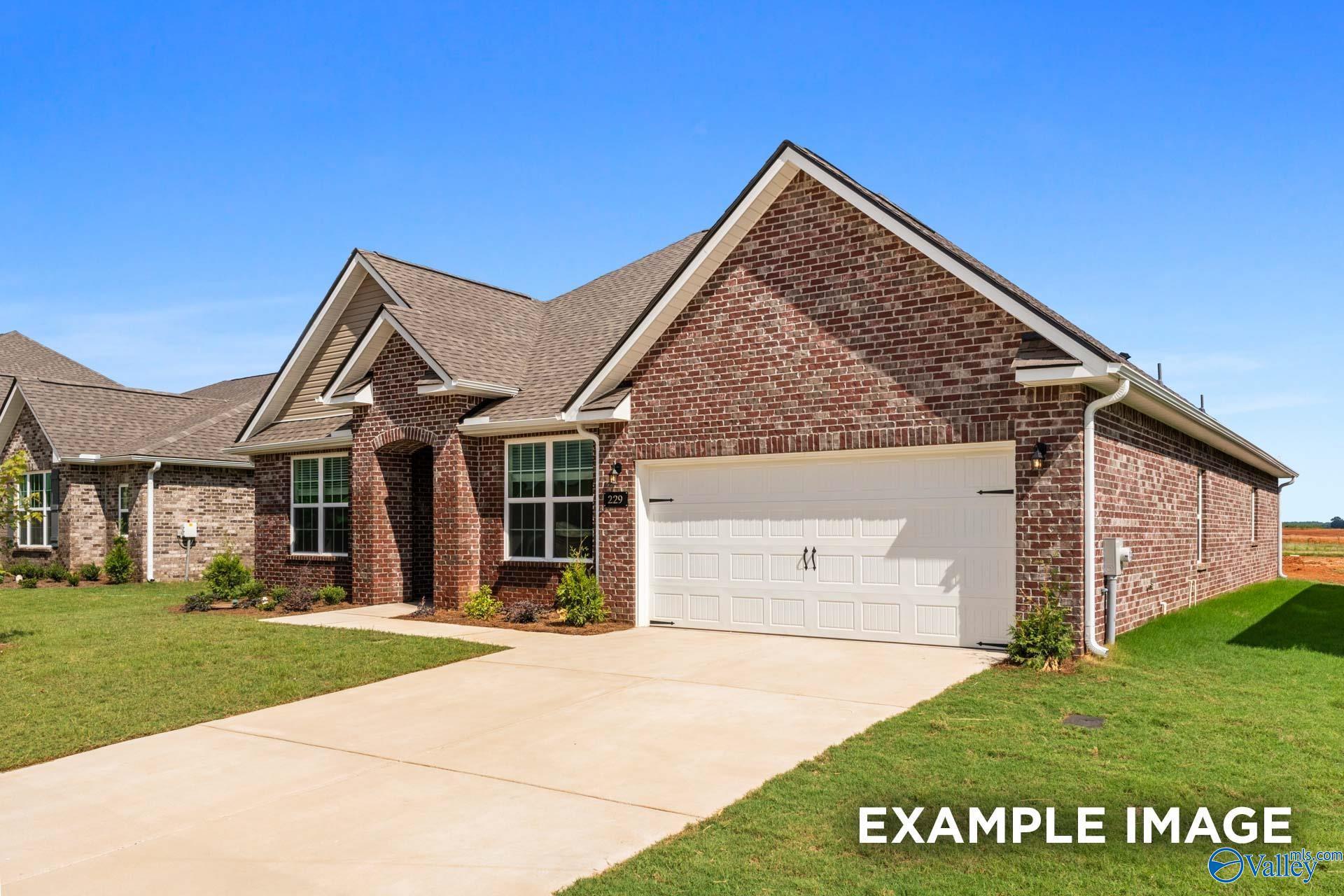 Single-story brick home with 2-car garage, gabled roof, and lush lawn in River Road Estates, Decatur, Alabama