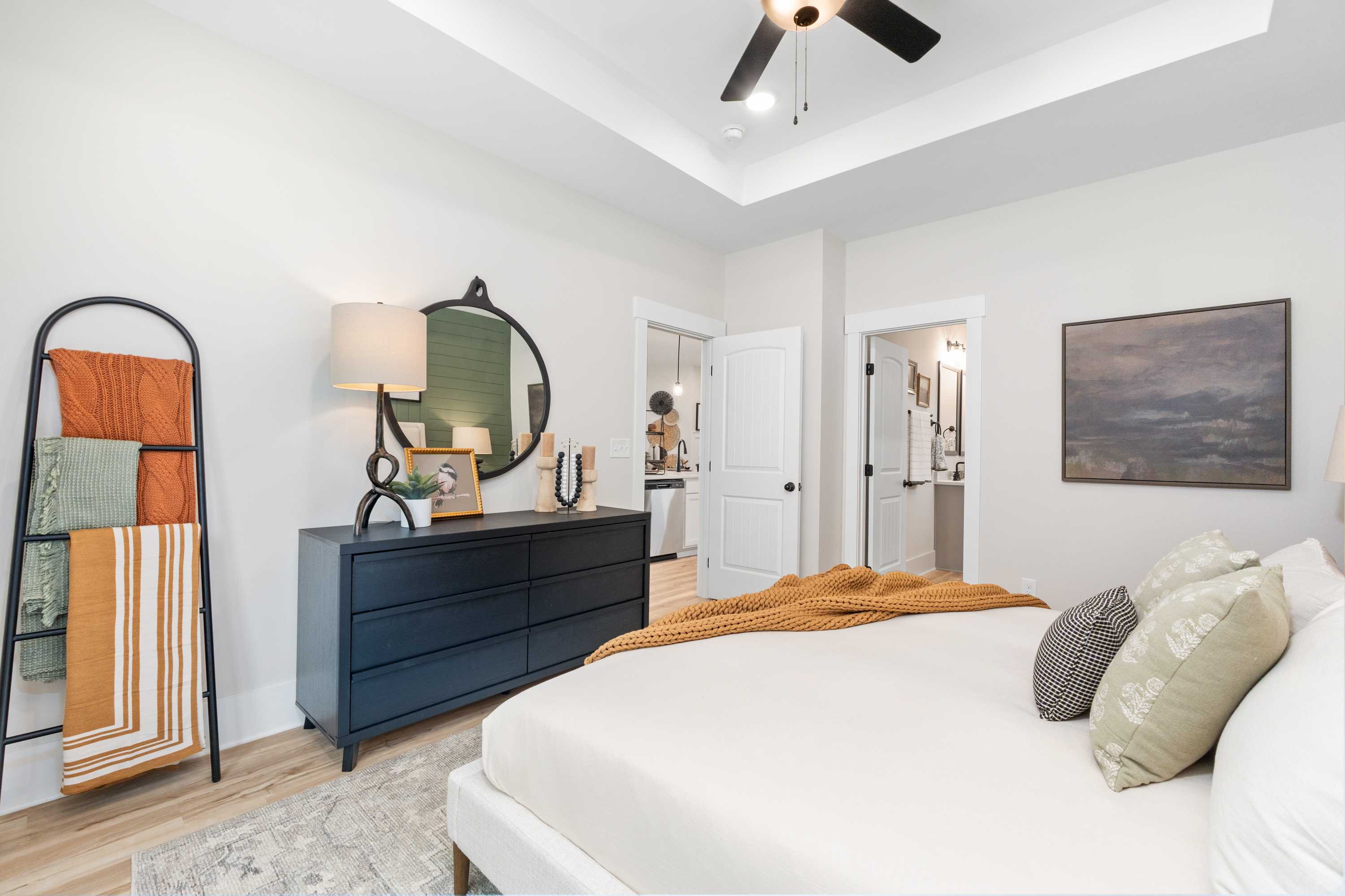Spacious primary bedroom at Spragins Cove in Huntsville AL with king bed neutral tones hardwood floors and modern accents
