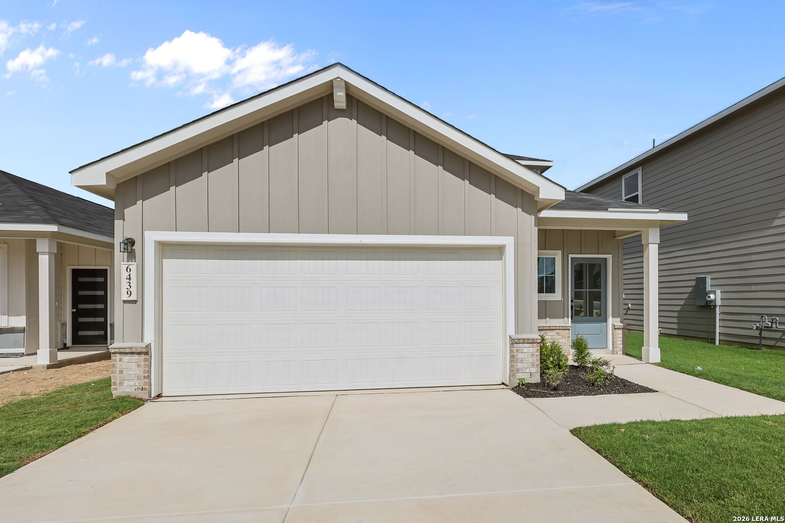 Two-car garage exterior with covered porch at Davidson Homes' Summit B plan in Morgan Meadows, San Antonio, Texas