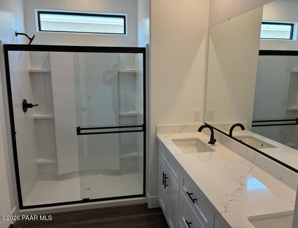 Modern bathroom with glass-enclosed walk-in shower and dual vanity in The Durango II G at South Ranch, Prescott, Arizona.