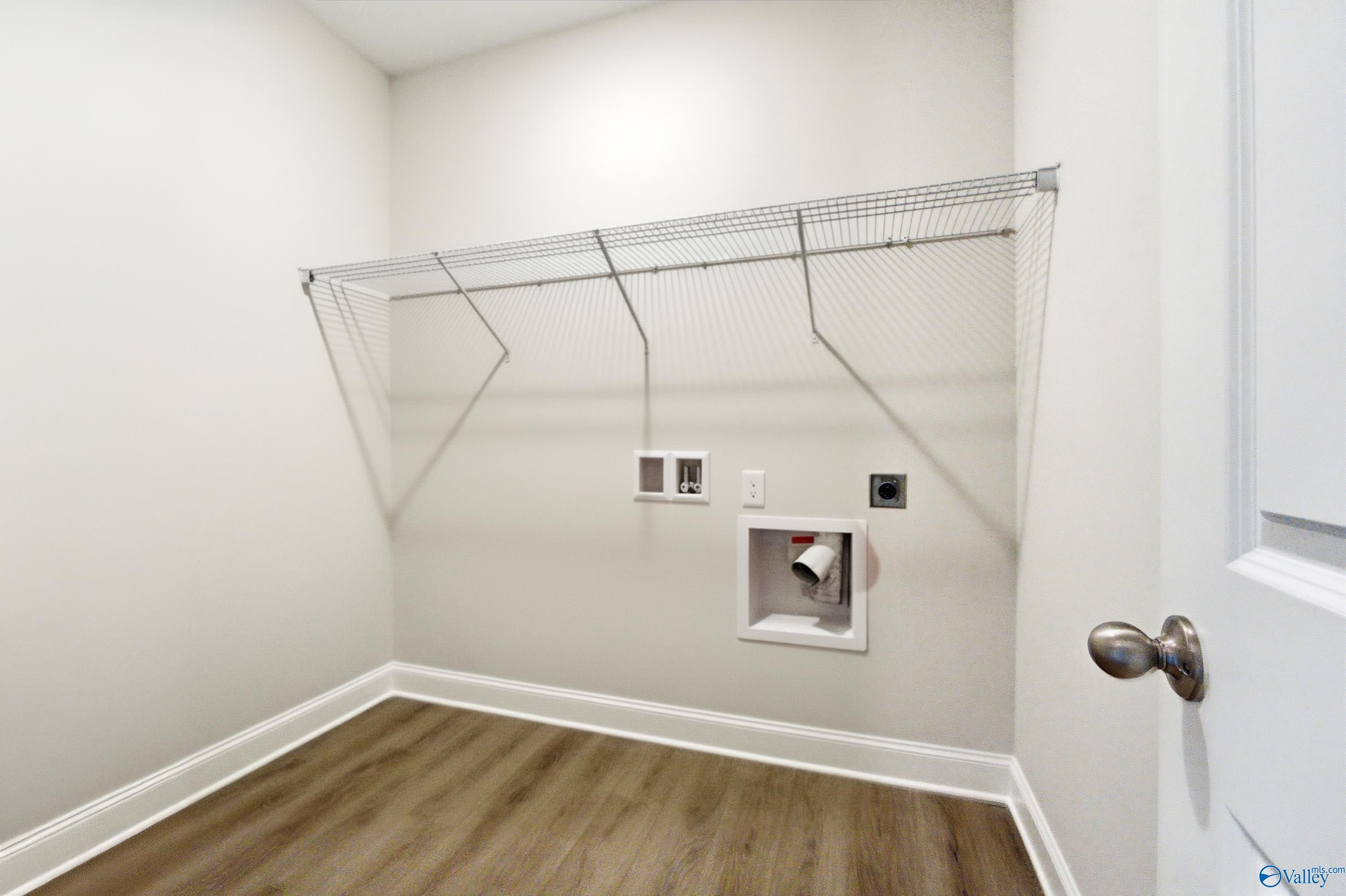 Bright laundry room with metal shelving, washer/dryer hookups in The Daphne C 4-bedroom home, Davidson Homes, Arab, Alabama