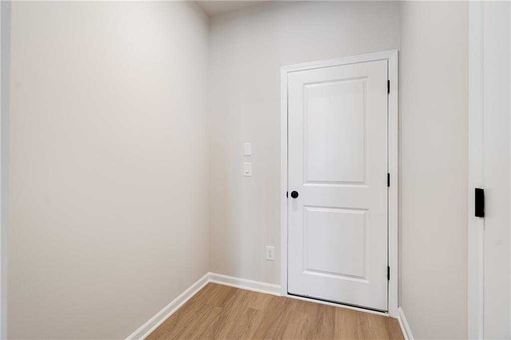 Cozy secondary bedroom with white panel door, hardwood floors, and neutral walls in Davidson Homes The Marion A, Kennesaw, GA