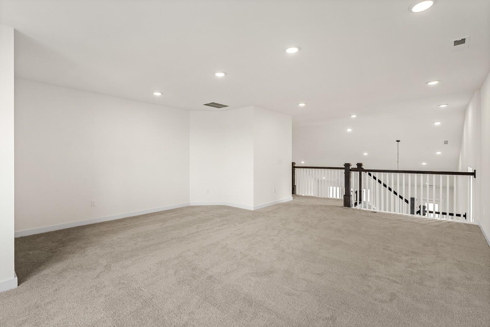 Spacious carpeted loft area with recessed lighting in The Ridgeport D floor plan by Davidson Homes in Mt. Juliet, TN.