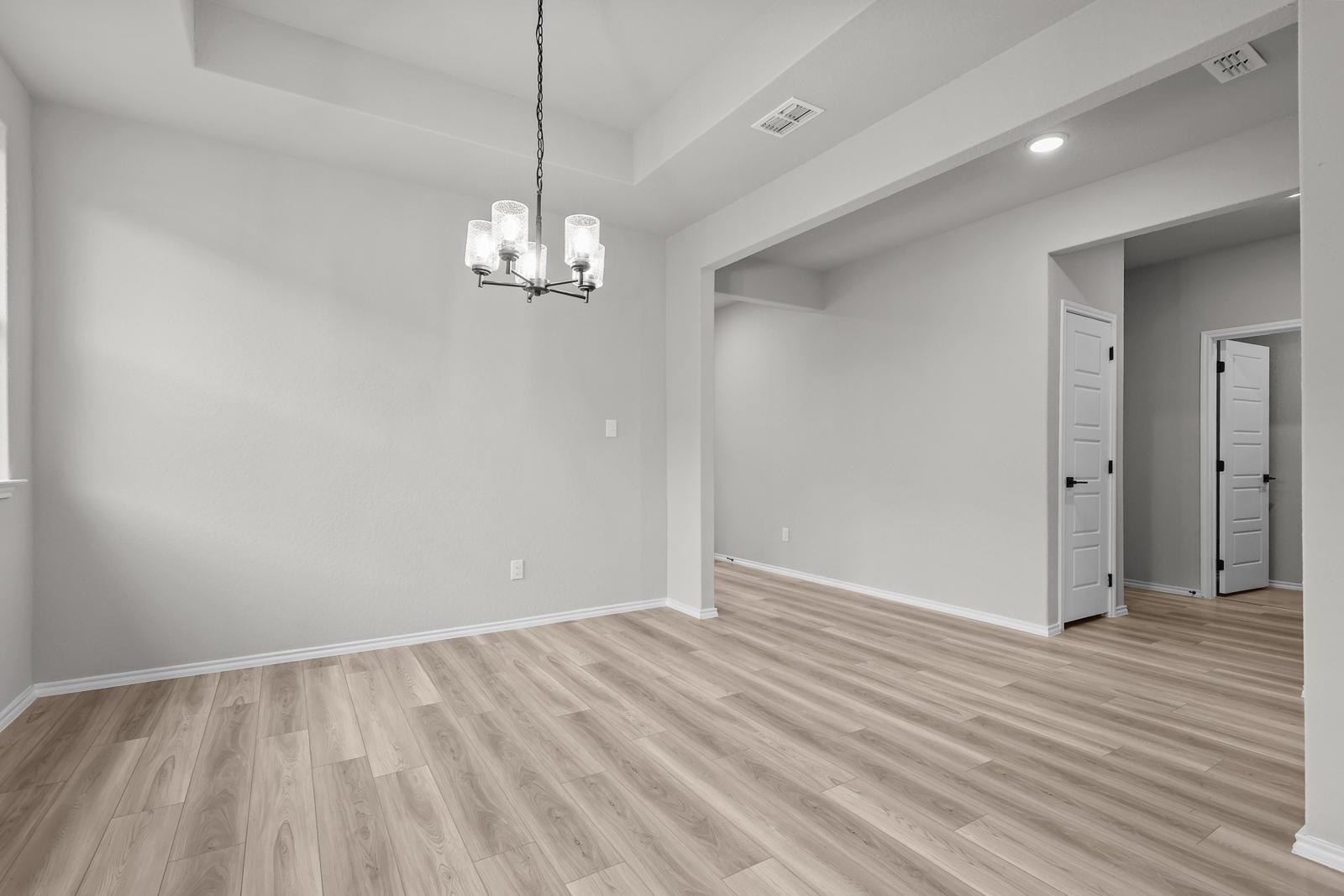 Bright dining area with tray ceiling and modern chandelier in The Glenwood E floor plan by Davidson Homes.