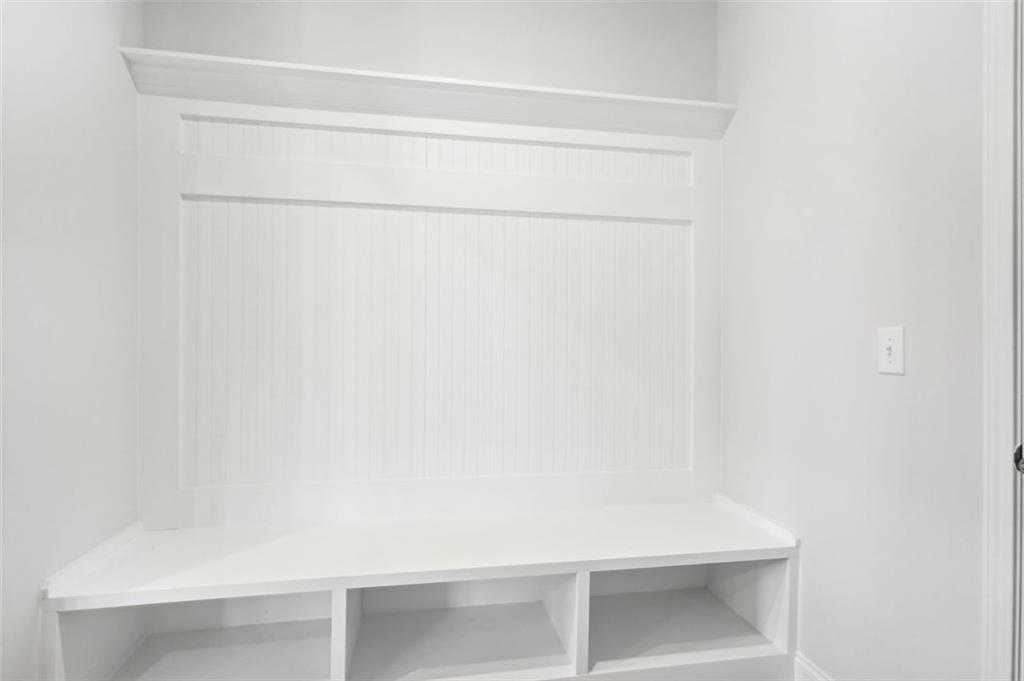 White shiplap mudroom bench with storage cubbies in Davidson Homes The Hickory C, Hoschton, Georgia