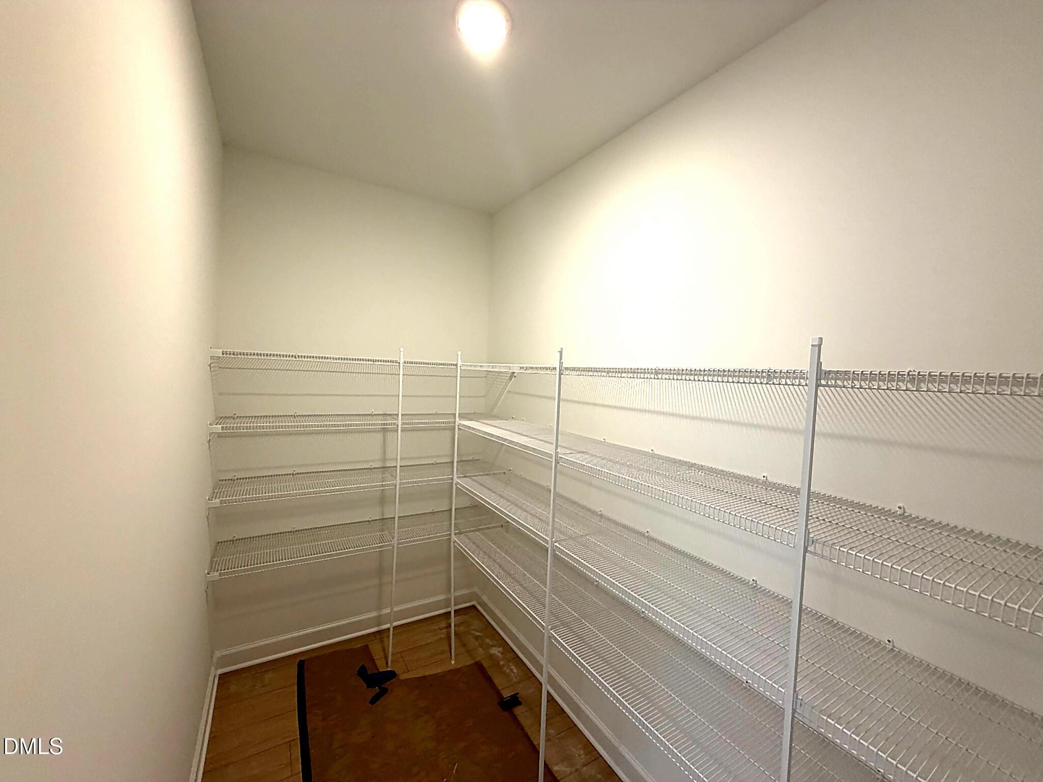 Spacious walk-in closet with wire shelving and hardwood flooring in Davidson Homes The Daphne C, Lillington, NC