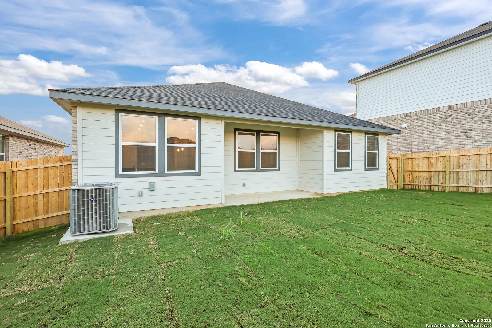Rear view of The Asheville J single-story home by Davidson Homes in Comanche Ridge, San Antonio, Texas, with covered patio and lush green yard