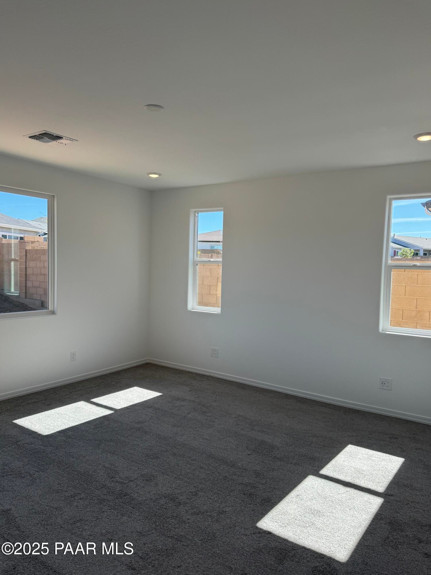 Bright bedroom with large sunny windows, white walls, and neutral carpet in Davidson Homes The Sunrise II A, Prescott Arizona