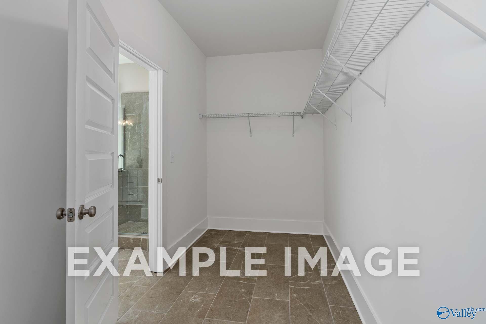 Spacious walk-in closet with wire shelving and tile flooring in Davidson Homes' The Harrison, Cain Park, Hartselle, Alabama
