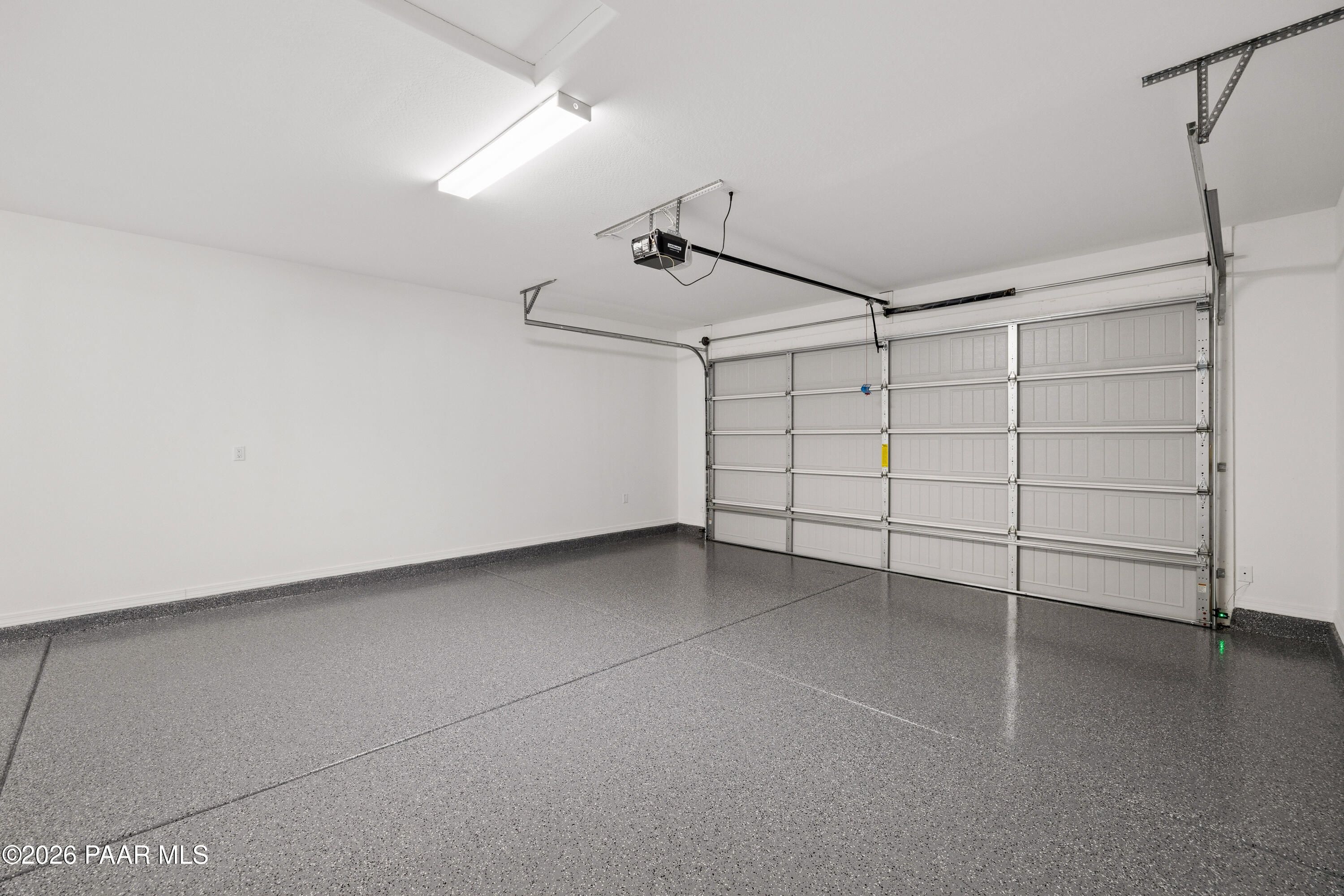 Spacious 3-car garage with epoxy-coated floor and overhead doors in Davidson Homes The Harmony A, Prescott Valley, Arizona