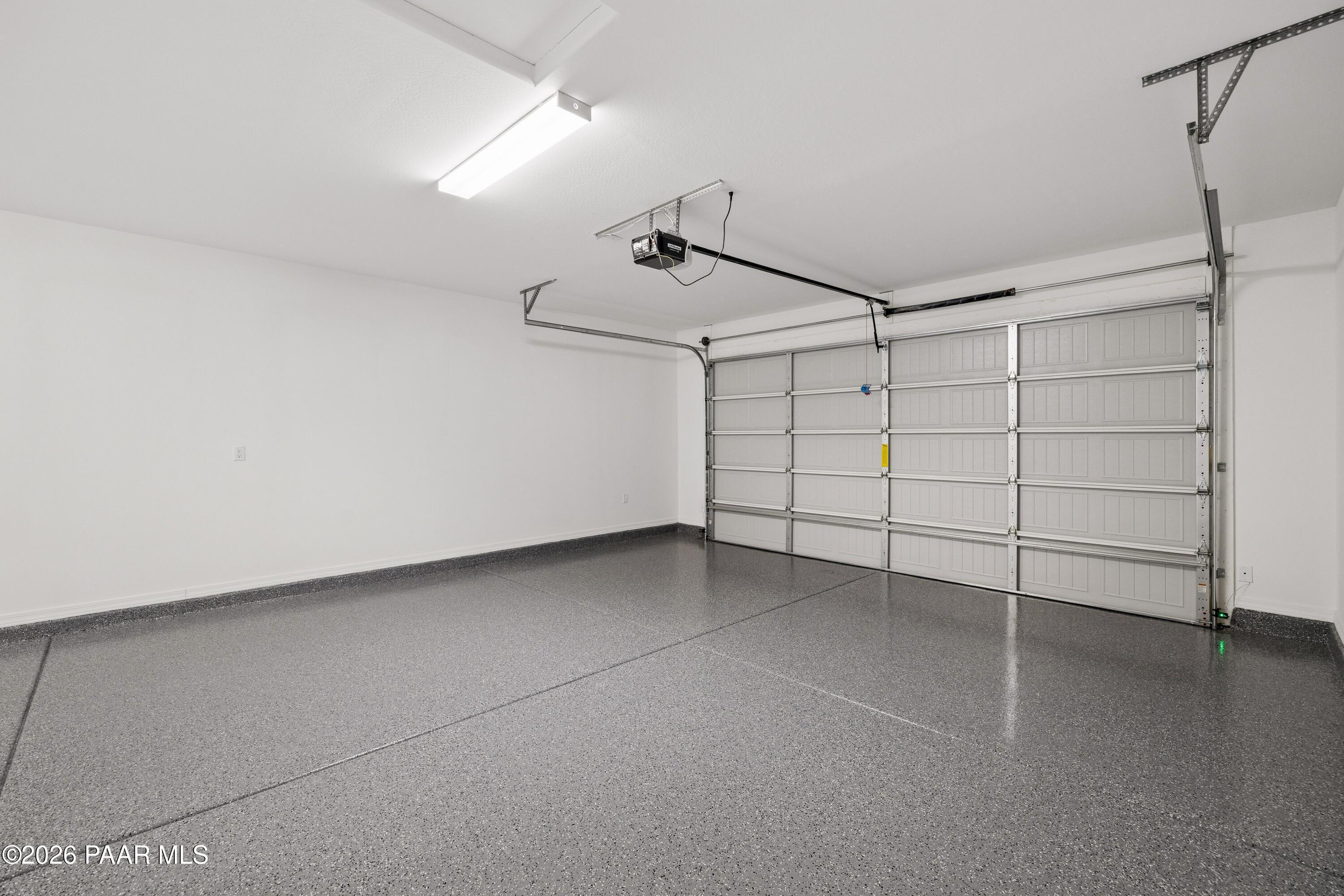 Spacious 3-car garage with epoxy-coated floor and overhead doors in Davidson Homes The Harmony A, Prescott Valley, Arizona
