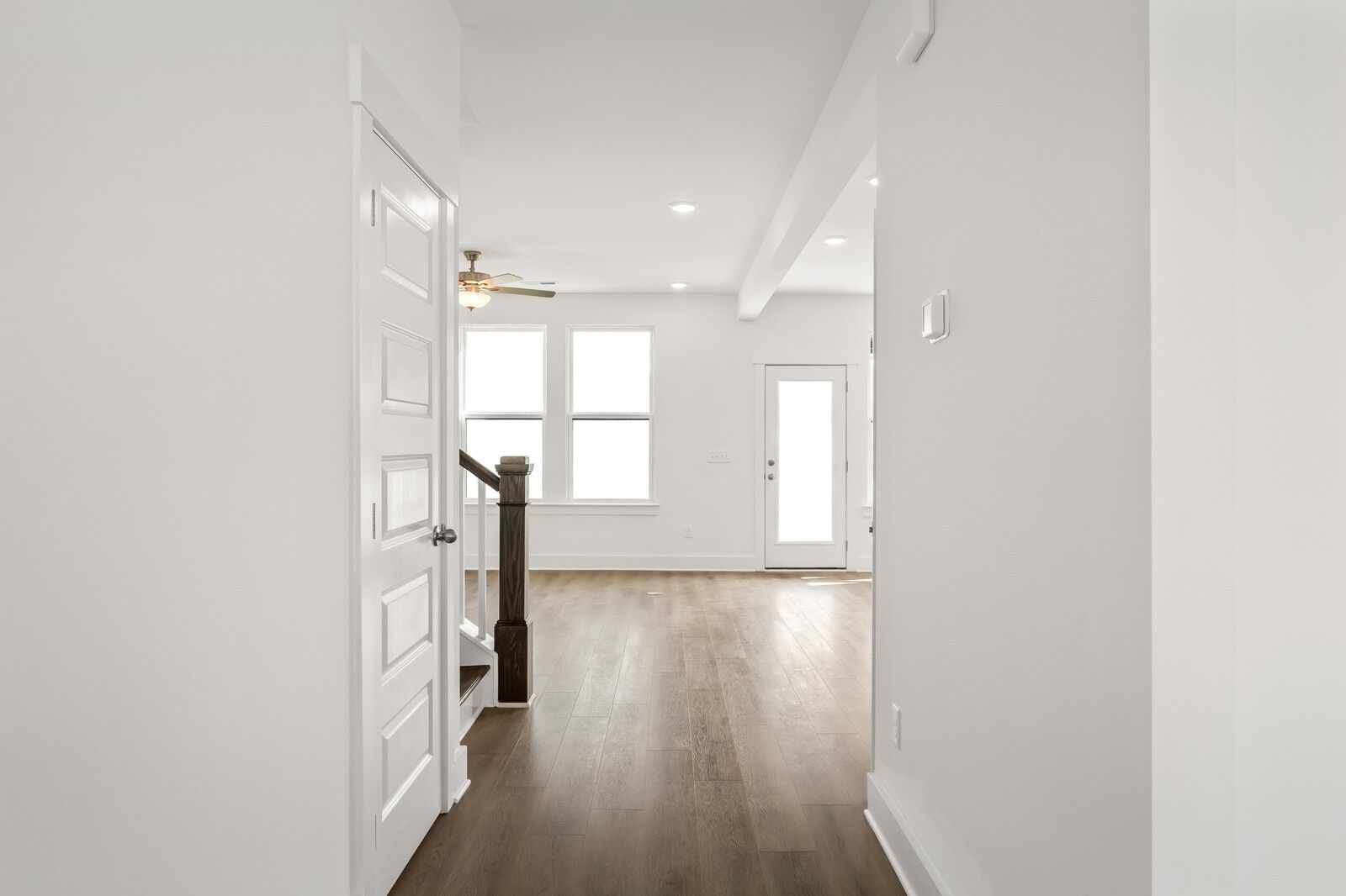 Bright entry hallway with wooden staircase, ceiling fan, and glass door in The Willow D floor plan, Mt. Juliet home