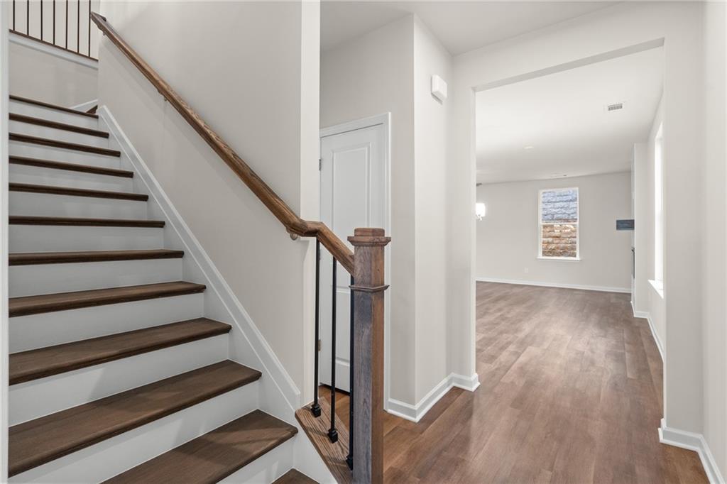 Elegant wooden staircase with wrought iron balusters in bright hallway of Davidson Homes The Marion B, Kennesaw, Georgia