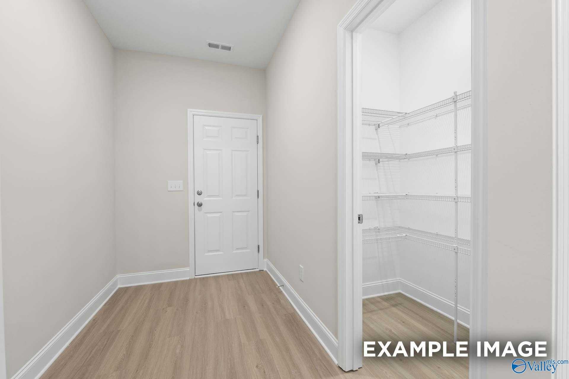 Spacious walk-in closet with wire shelving and hardwood floors in master bedroom, The Camden C by Davidson Homes, Huntsville AL