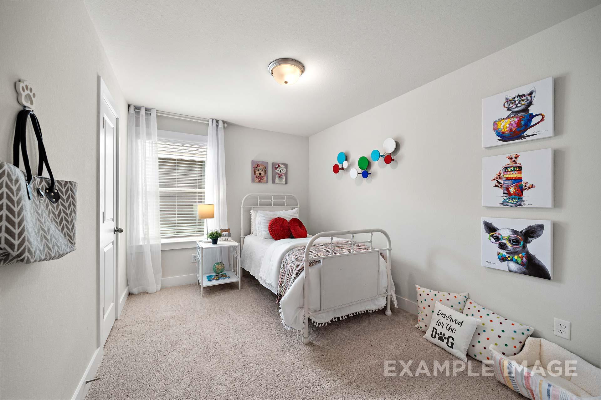 Playful children's bedroom in The Lily A home design featuring twin bed, red pillows, wall art, and beige carpet