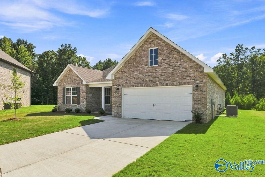 Brick front exterior with 2-car garage and landscaped lawn at The Rockford by Davidson Homes in Cain Park, Hartselle, Alabama