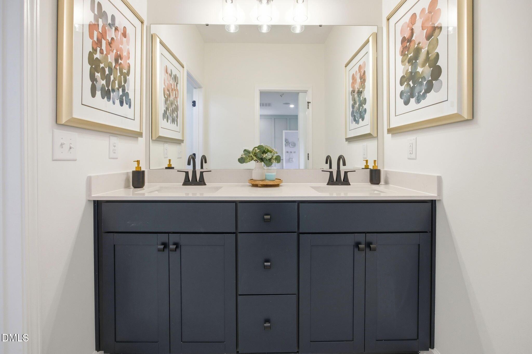 Modern double vanity with navy cabinets and quartz countertop in Davidson Homes The Ashport M floor plan at Wendell Ridge.