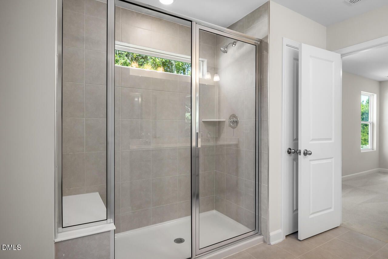 Tiled walk-in shower with glass door in The Gavin A floor plan at Gregory Village, Lillington, NC by Davidson Homes.
