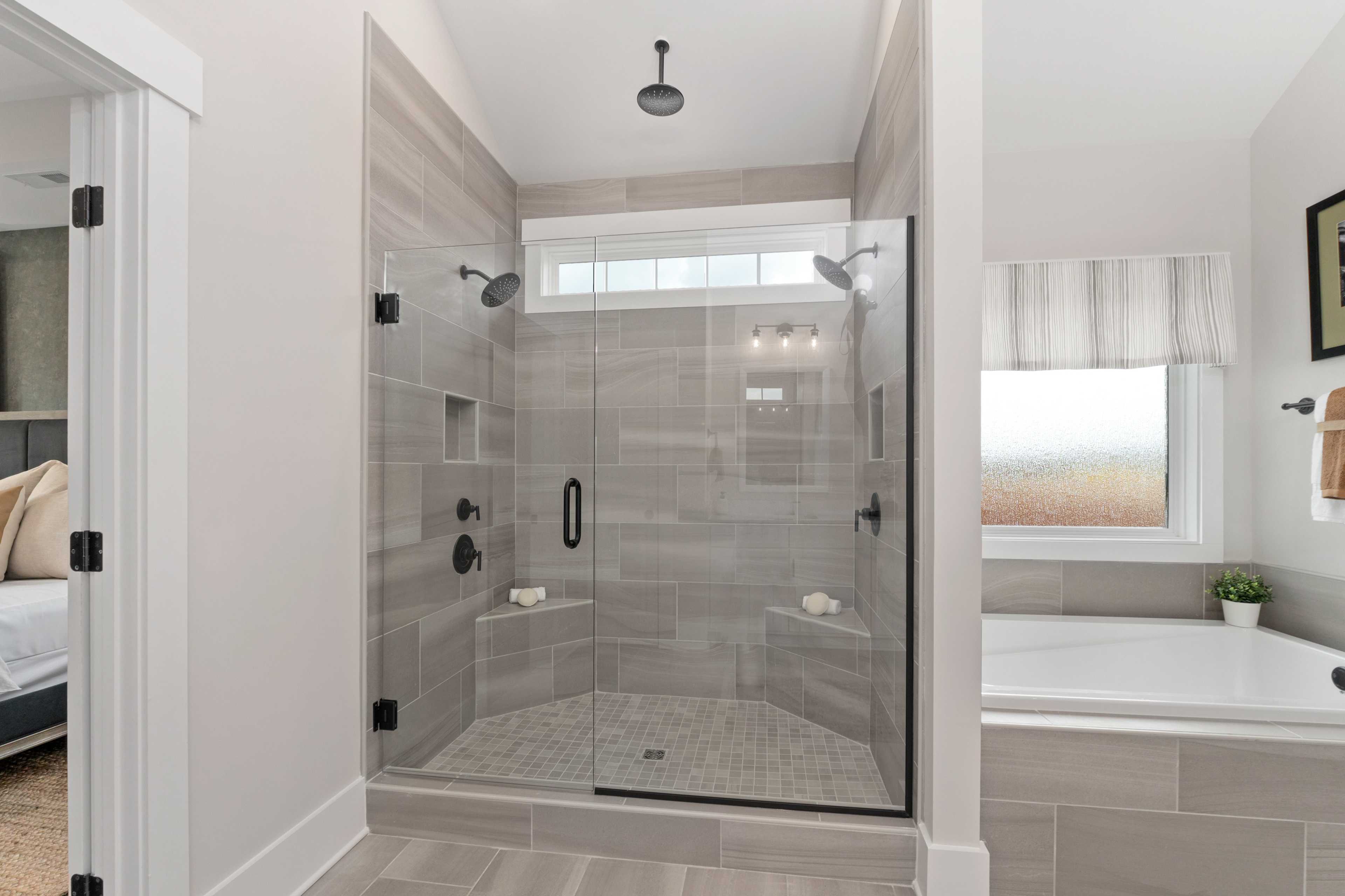 Luxurious master bathroom at Briercreek in Meridianville AL with frameless glass shower, soaking tub, and neutral tiles