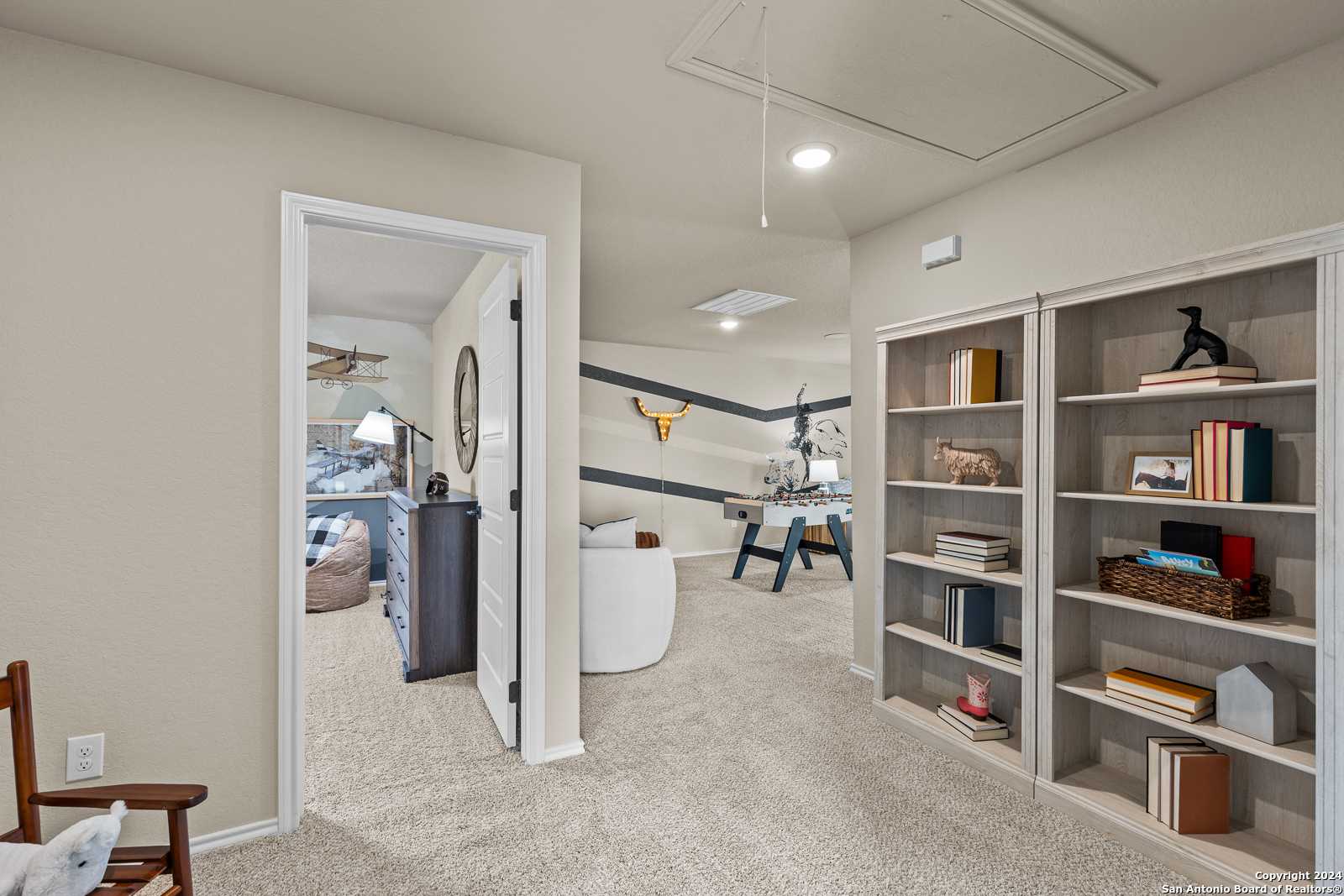 Cozy child's bedroom with built-in bookshelves, study desk, queen bed, and Texas-themed decor in Davidson Homes The Douglas F, Bricewood, San Antonio