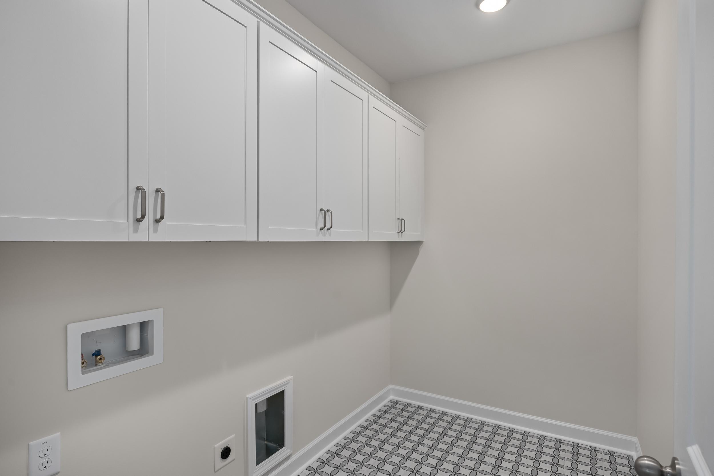 Spacious laundry room in The Beech A with white shaker cabinets, washer-dryer hookups, and neutral tiled floor