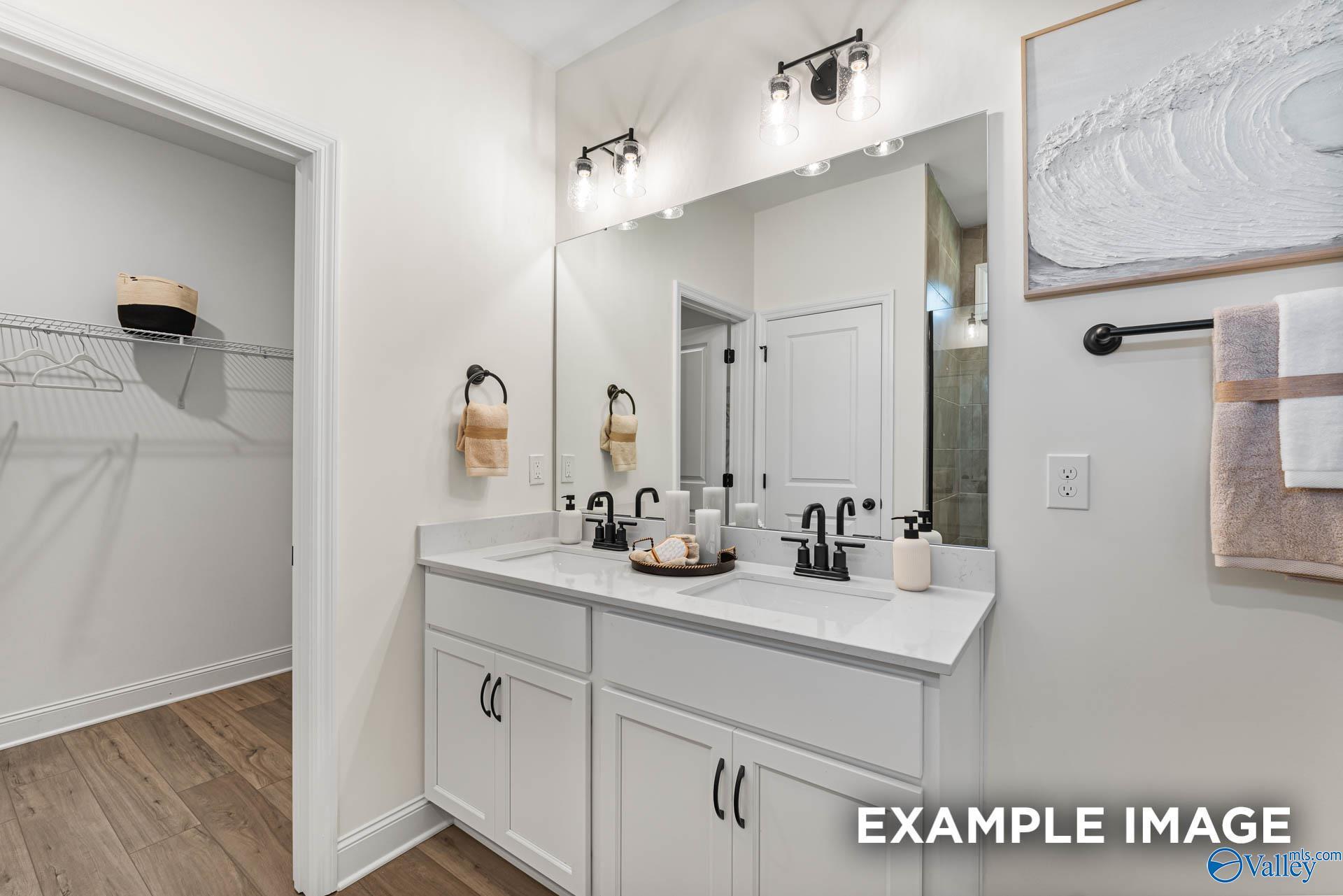 Double vanity bathroom with quartz countertops and walk-in closet in The Franklin floor plan, Blue Spring, Huntsville, AL.
