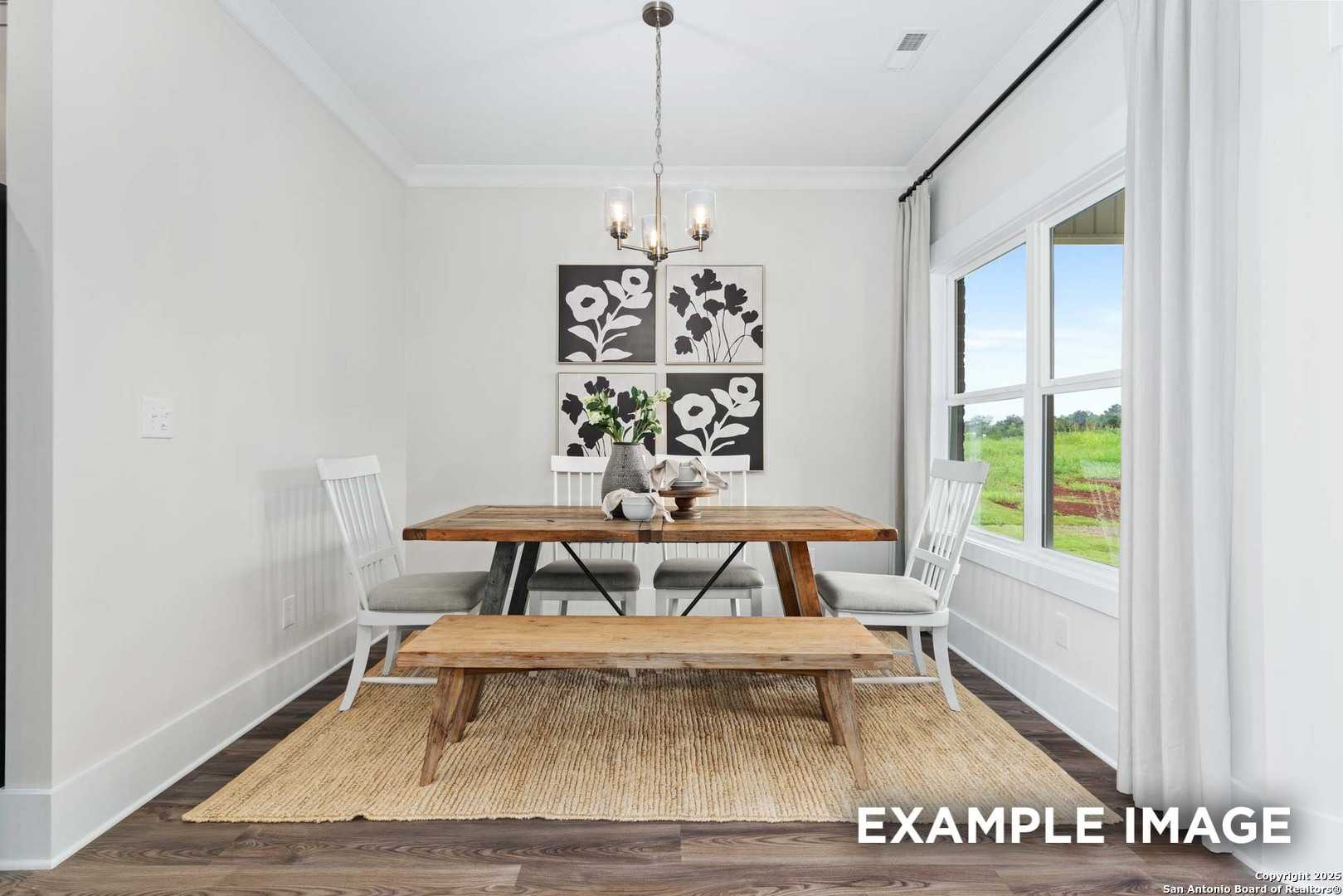 Bright dining room with farmhouse wooden table, bench, chairs, chandelier, and window view in The Daphne H, Seguin, Texas