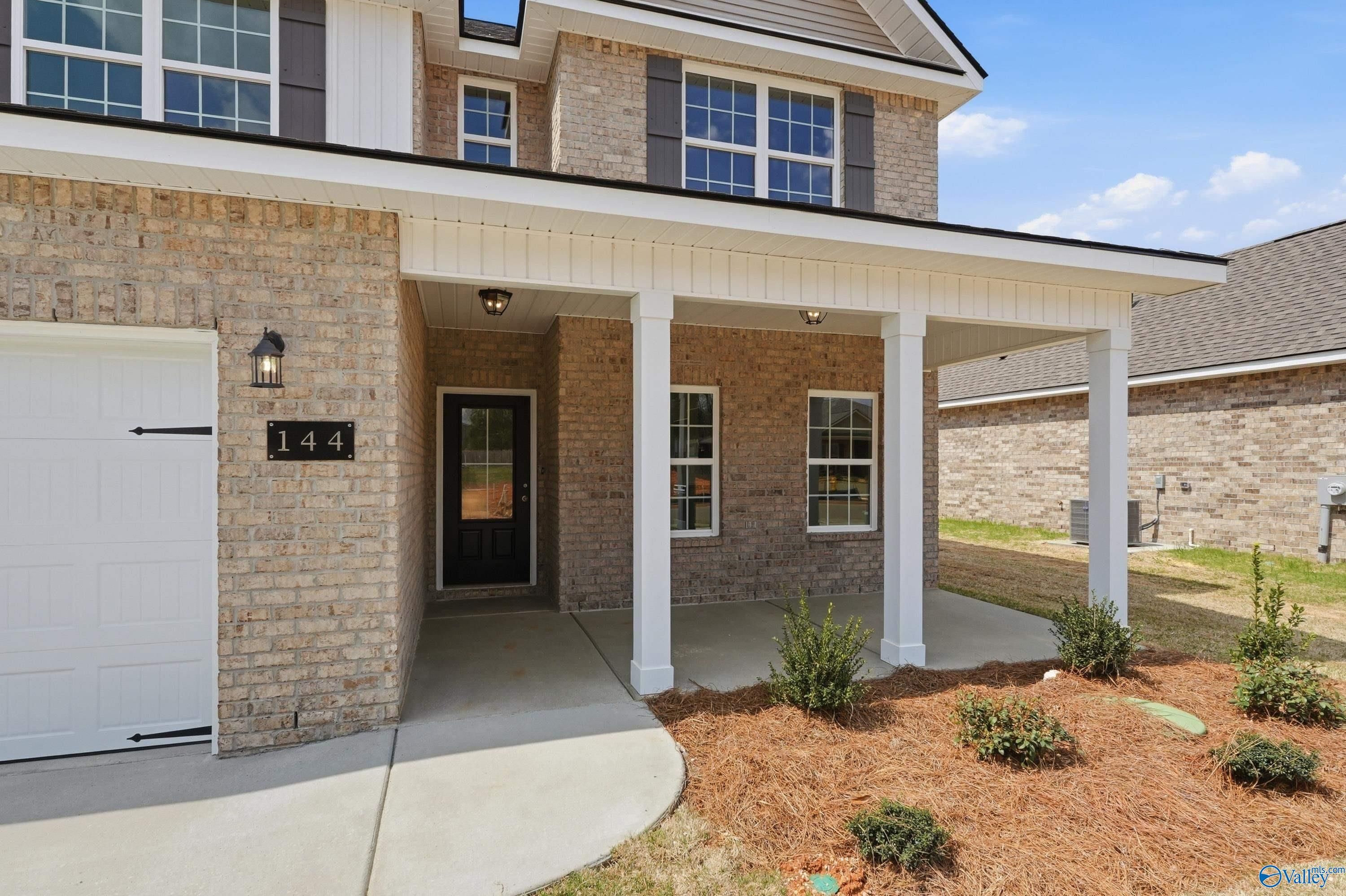 Two-story brick home with covered porch, columns, and two-car garage in Creek Grove, New Market, Alabama - Davidson Homes The Shelby B