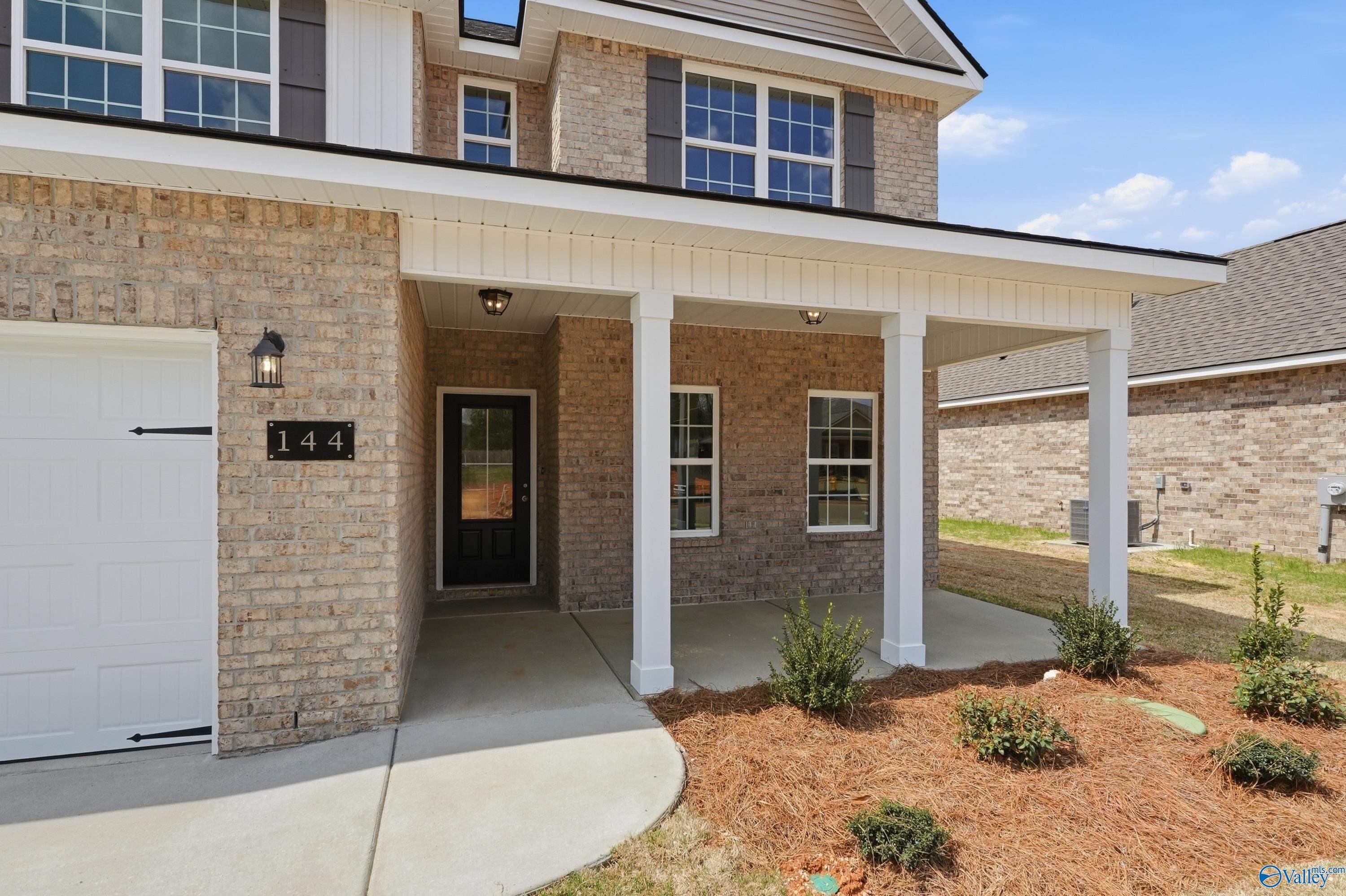 Two-story brick home with covered porch, columns, and two-car garage in Creek Grove, New Market, Alabama - Davidson Homes The Shelby B