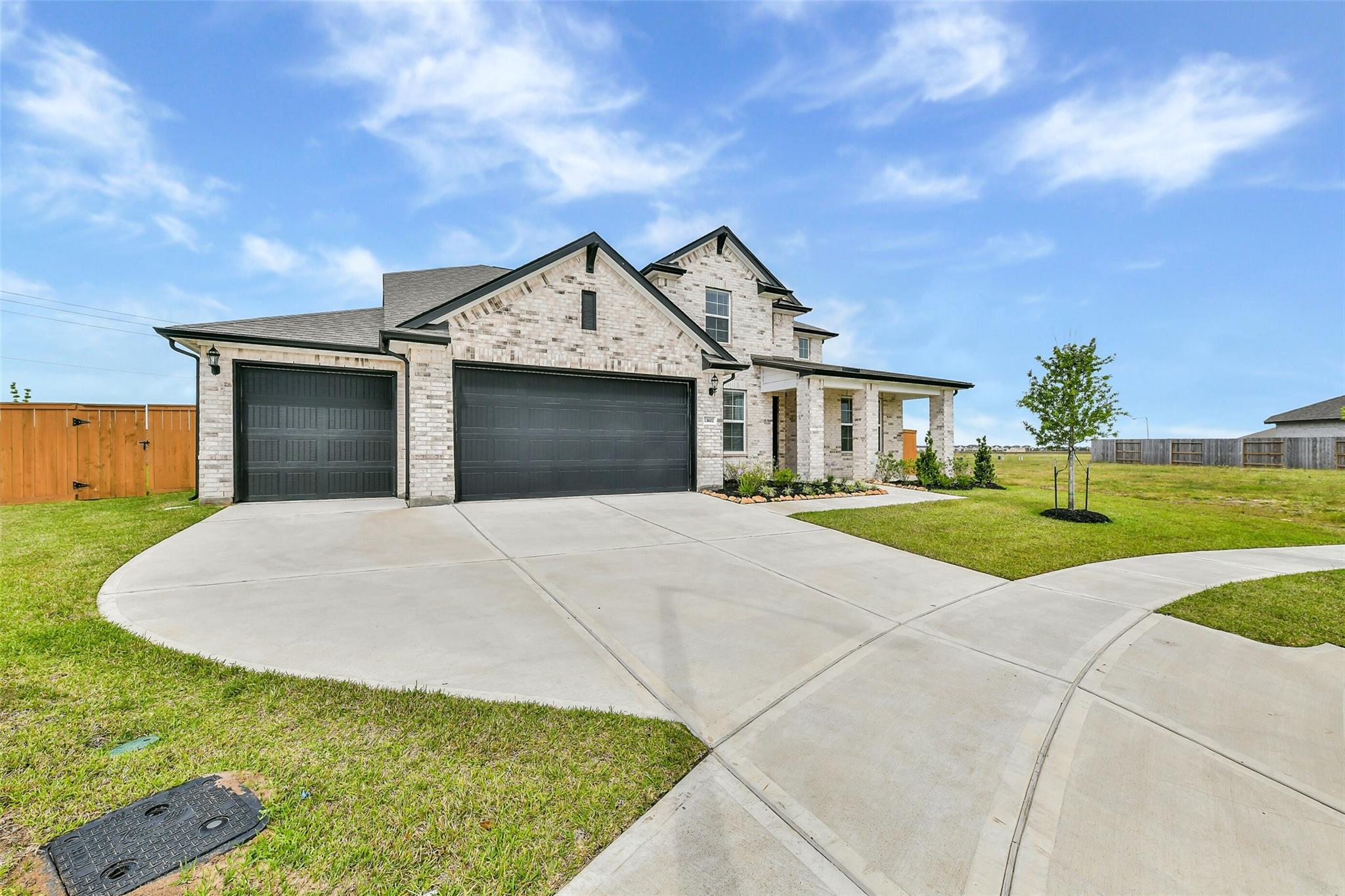 Two-story brick home with 4-car garage, curved driveway, and landscaped yard in Lago Mar, Texas City, Texas - Davidson Homes Victoria A