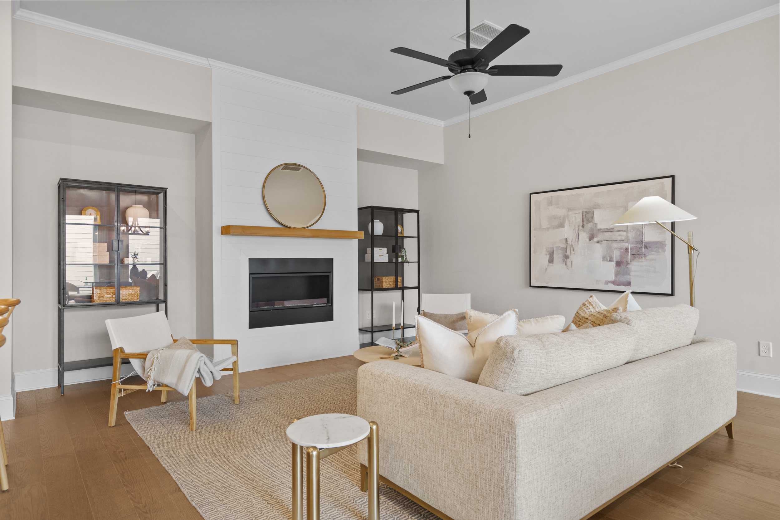 Cozy open-concept living room at The Village at Towne Lake in Woodstock GA with beige sofa, modern fireplace, and hardwood floors