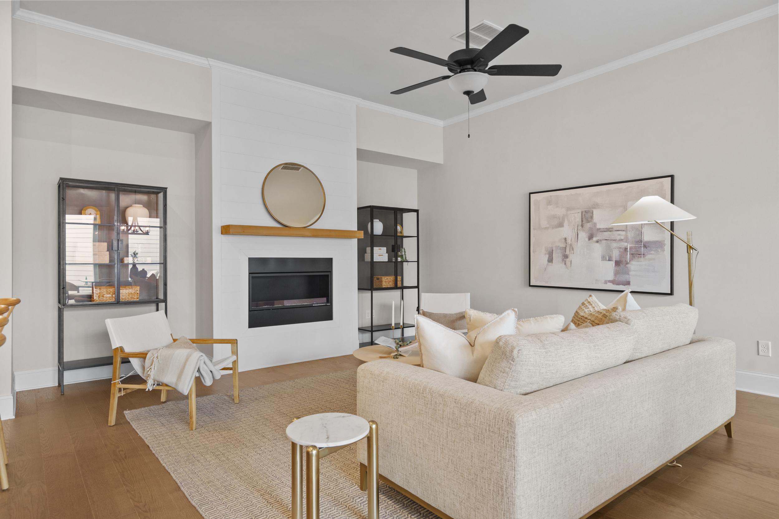 Cozy open-concept living room at The Village at Towne Lake in Woodstock GA with beige sofa, modern fireplace, and hardwood floors