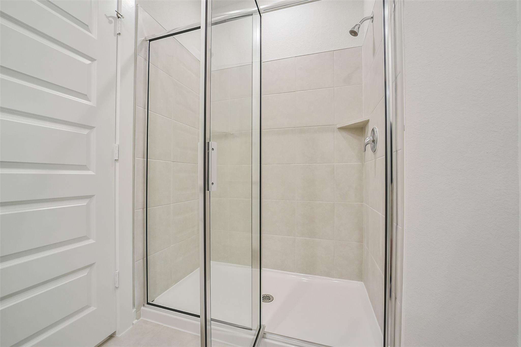 Modern frameless glass shower with white subway tiles in master bath, Davidson Homes The Frio F, Conroe, Texas