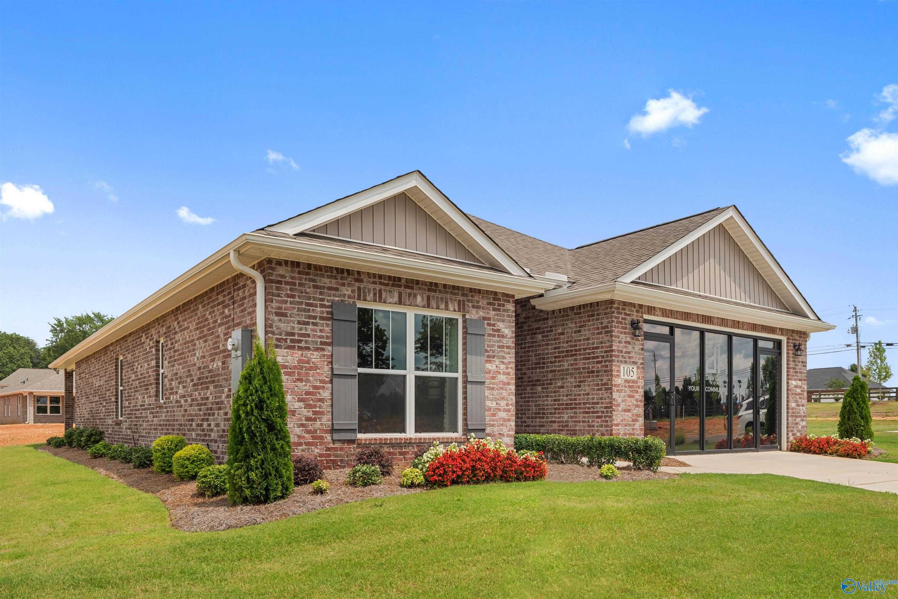 Brick single-story home with 2-car garage, large windows, and landscaped yard in Flint Meadows, New Market, Alabama