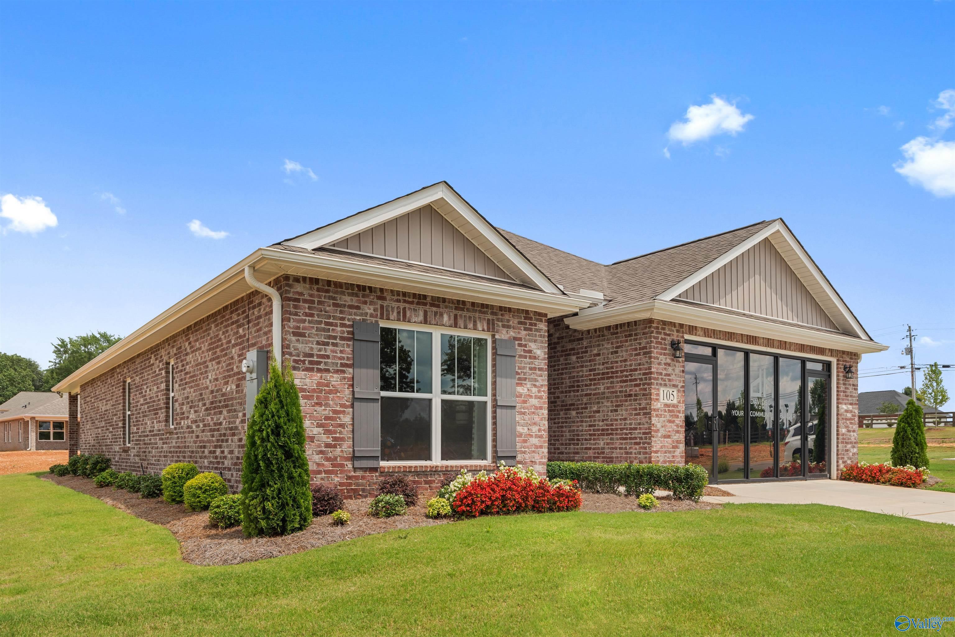 Brick single-story home with 2-car garage, large windows, and landscaped yard in Flint Meadows, New Market, Alabama