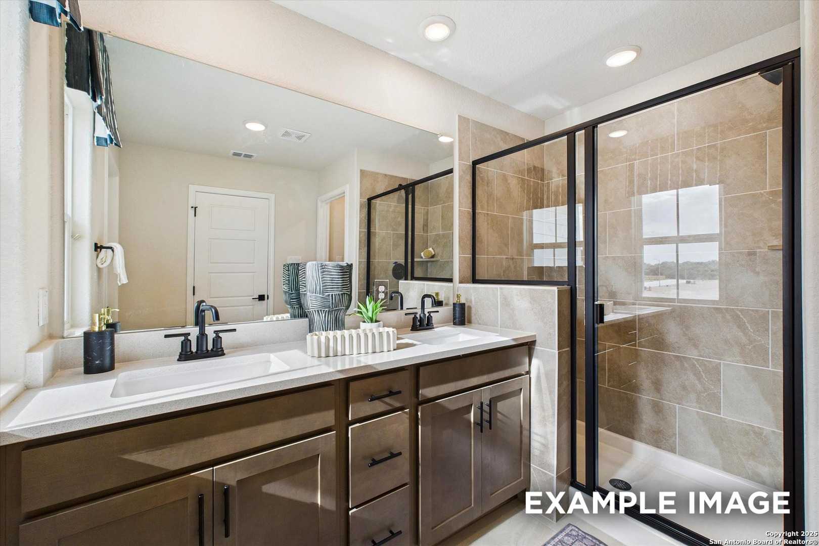Modern master bathroom featuring double vanity, frameless glass shower, and neutral tile in Davidson Homes The Florence C, San Antonio