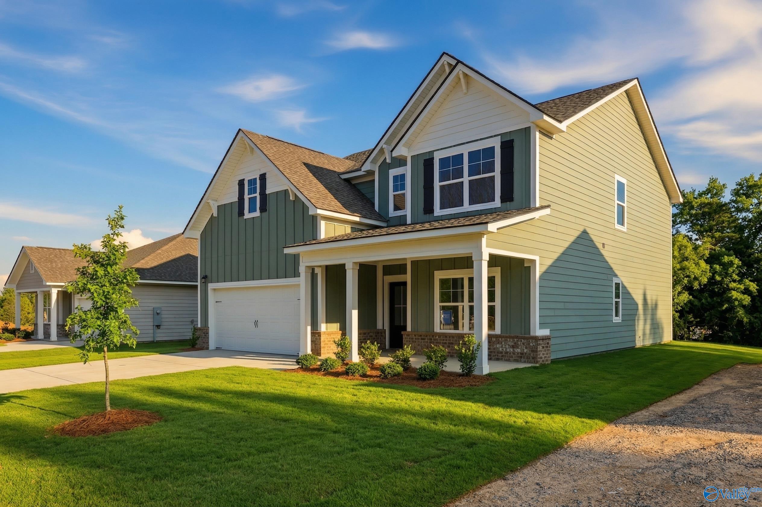 Two-story Chelsea D home by Davidson Homes with covered porch, two-car garage, and lush lawn in Noble Ridge, Cullman, Alabama