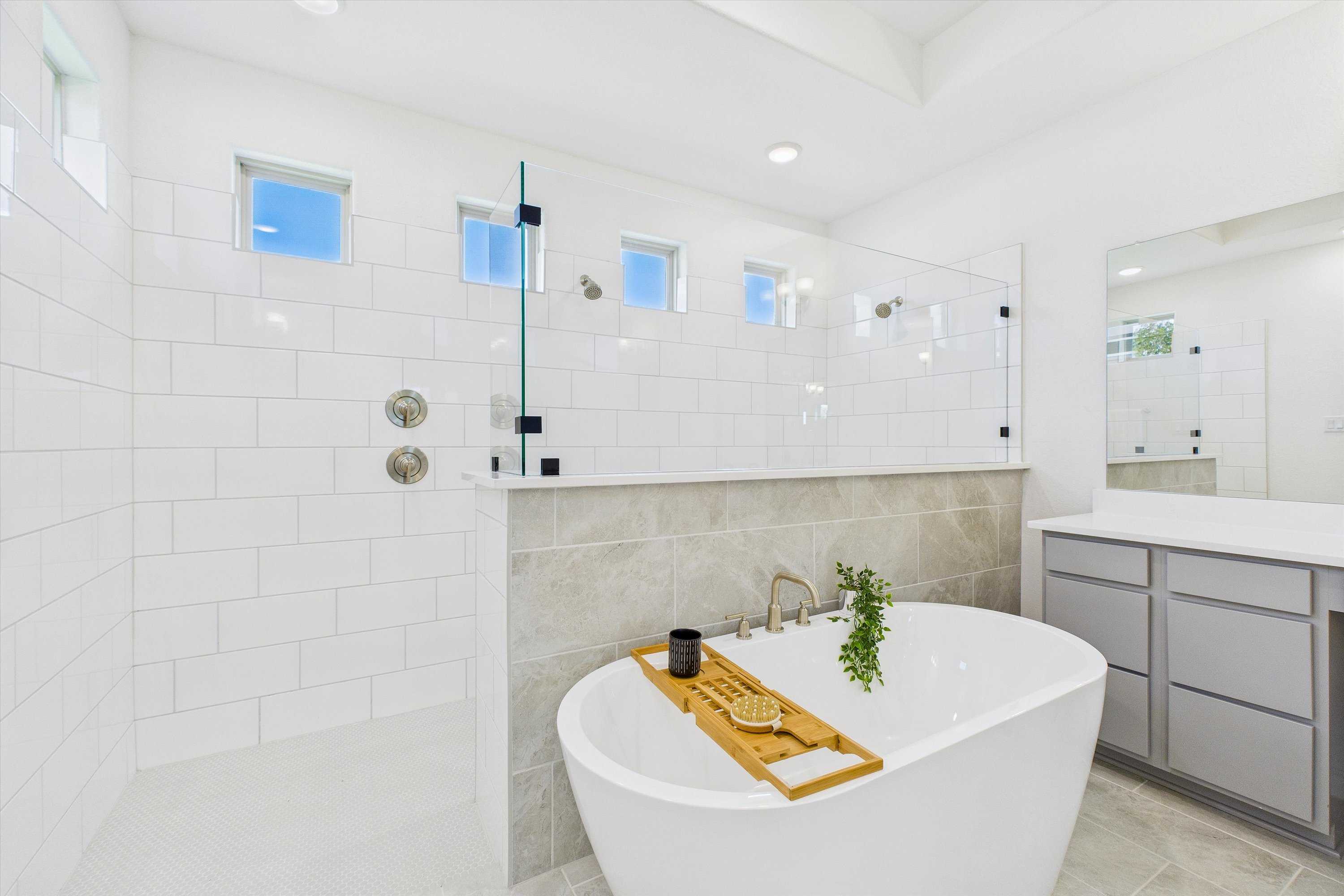 Luxurious master bathroom with freestanding tub, glass shower enclosure, and modern vanity in Davidson Homes The Summerlin C, Castroville, Texas