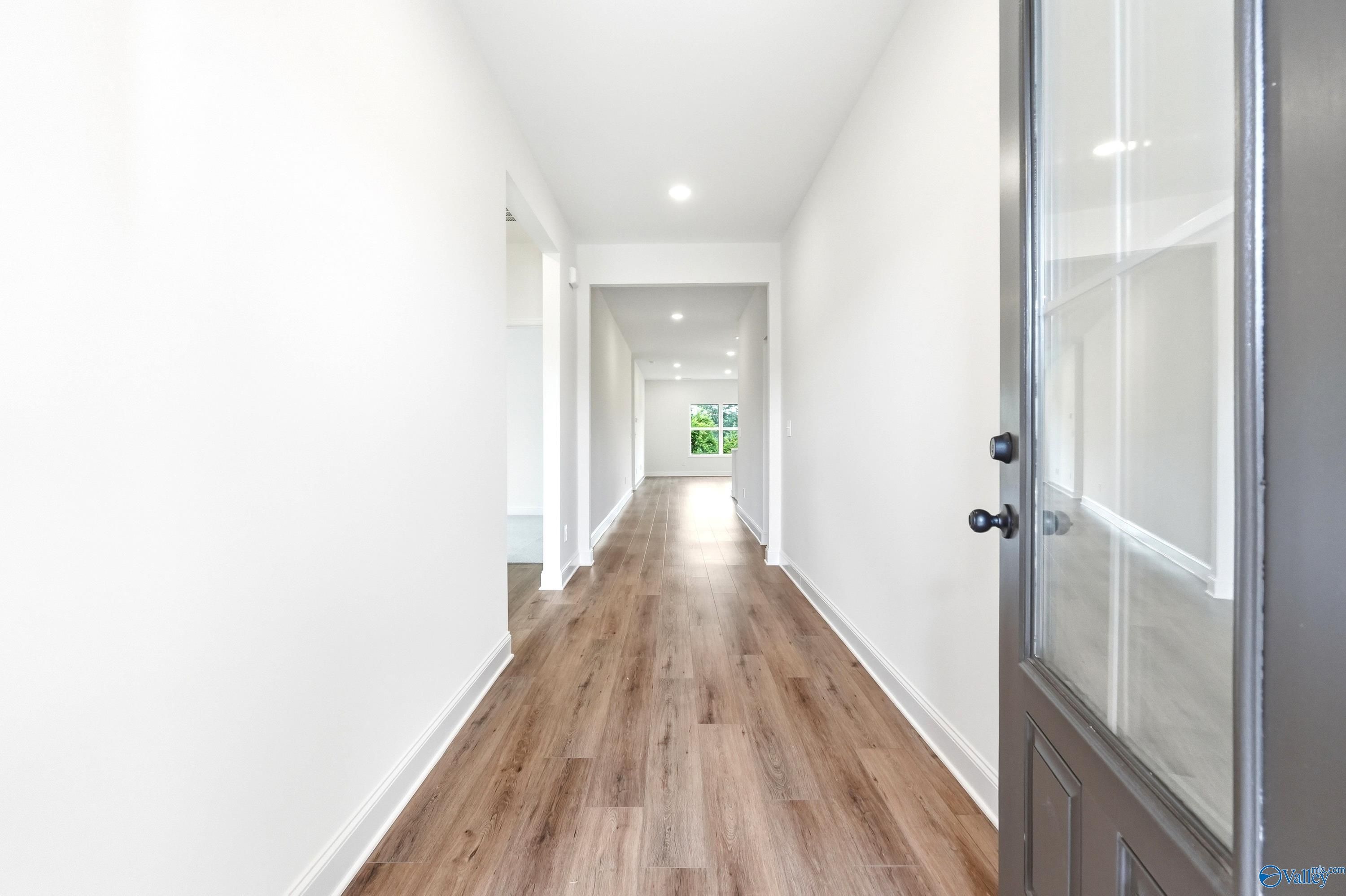 Bright foyer entryway with wood-look flooring in The Daphne C floor plan by Davidson Homes in Ivy Hills, Toney, Alabama.