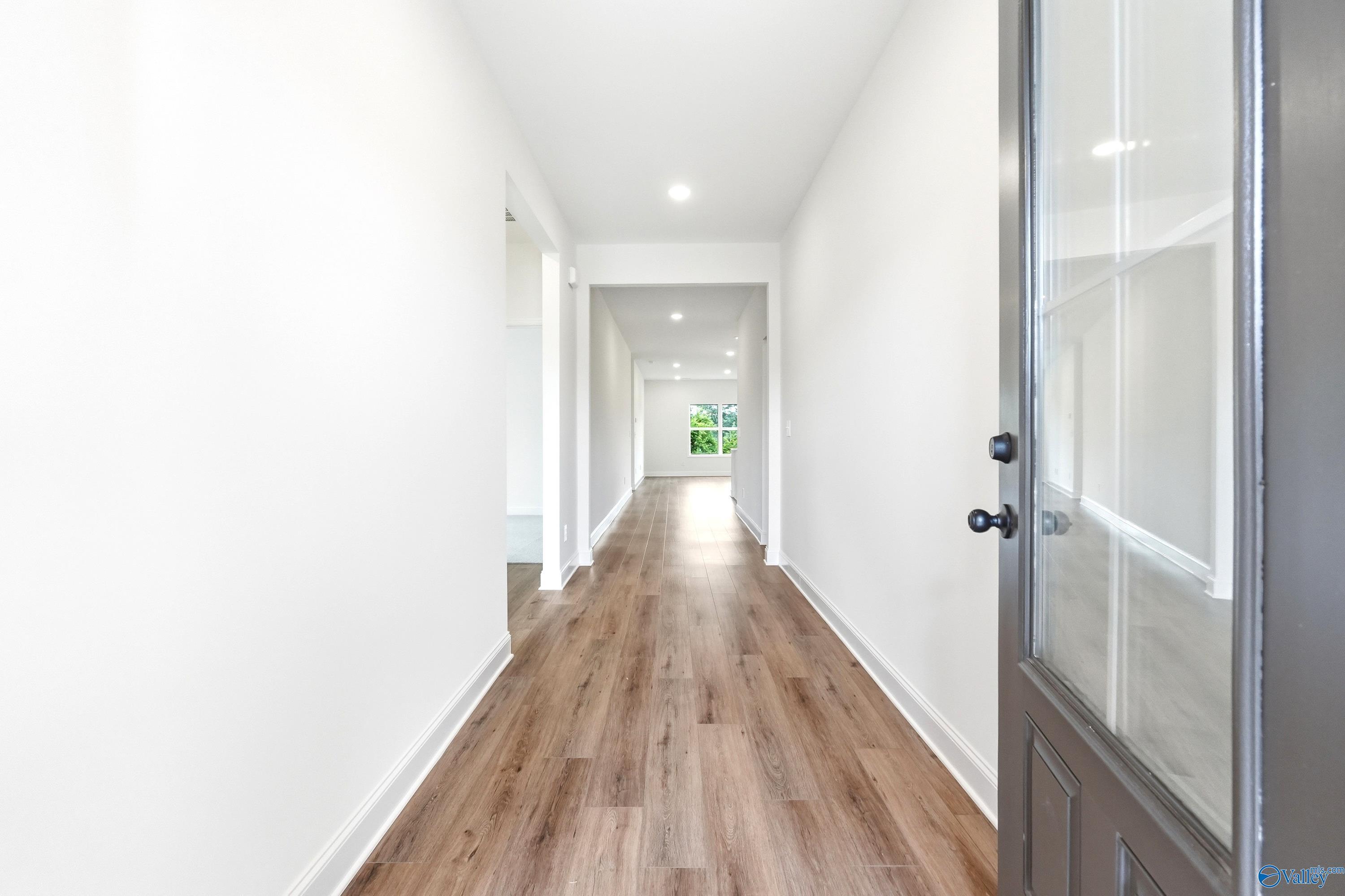 Bright foyer entryway with wood-look flooring in The Daphne C floor plan by Davidson Homes in Ivy Hills, Toney, Alabama.