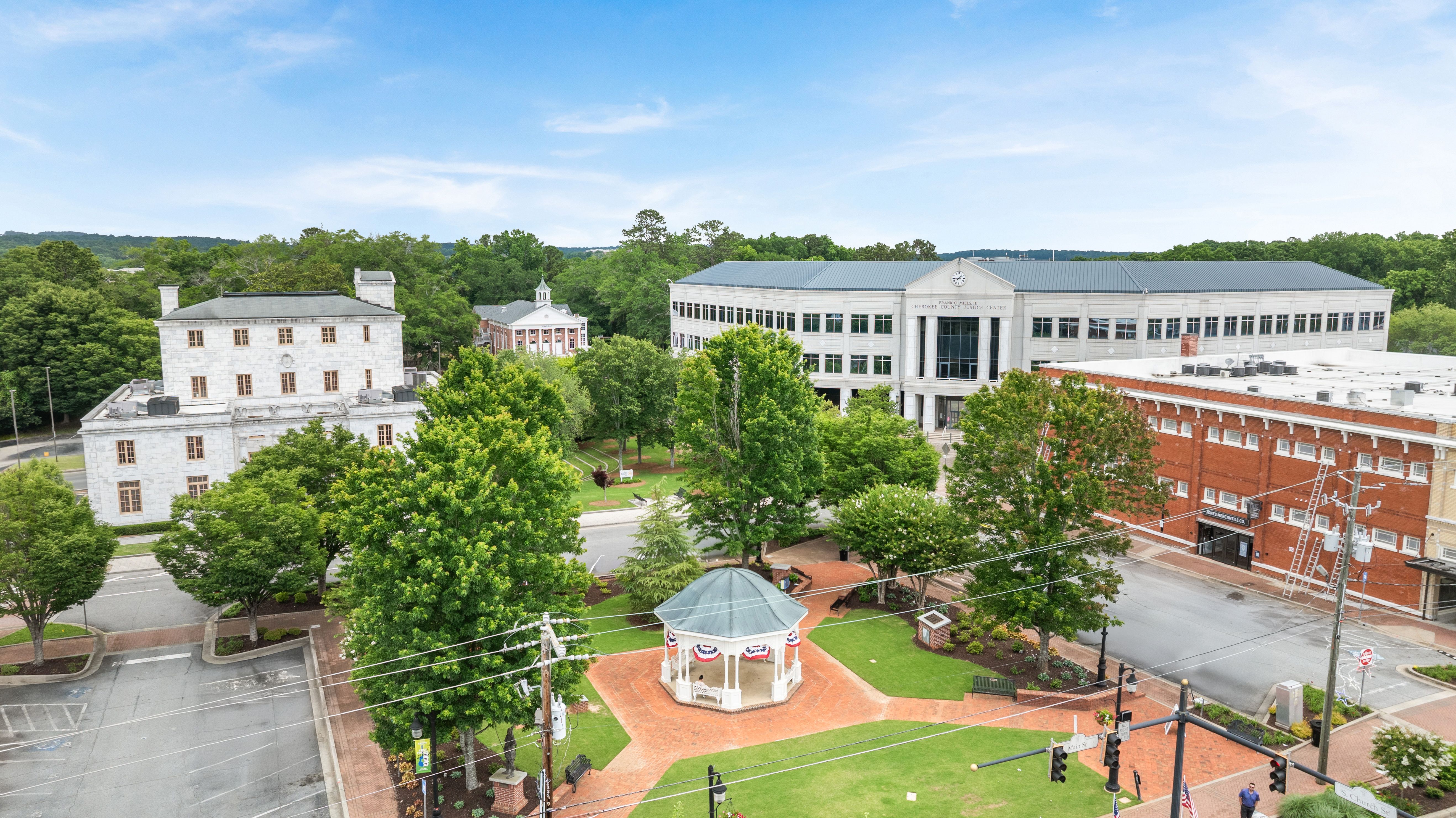Aerial view of downtown Canton, Georgia, featuring the public park, gazebo, and local landmarks near The Bluffs community.
