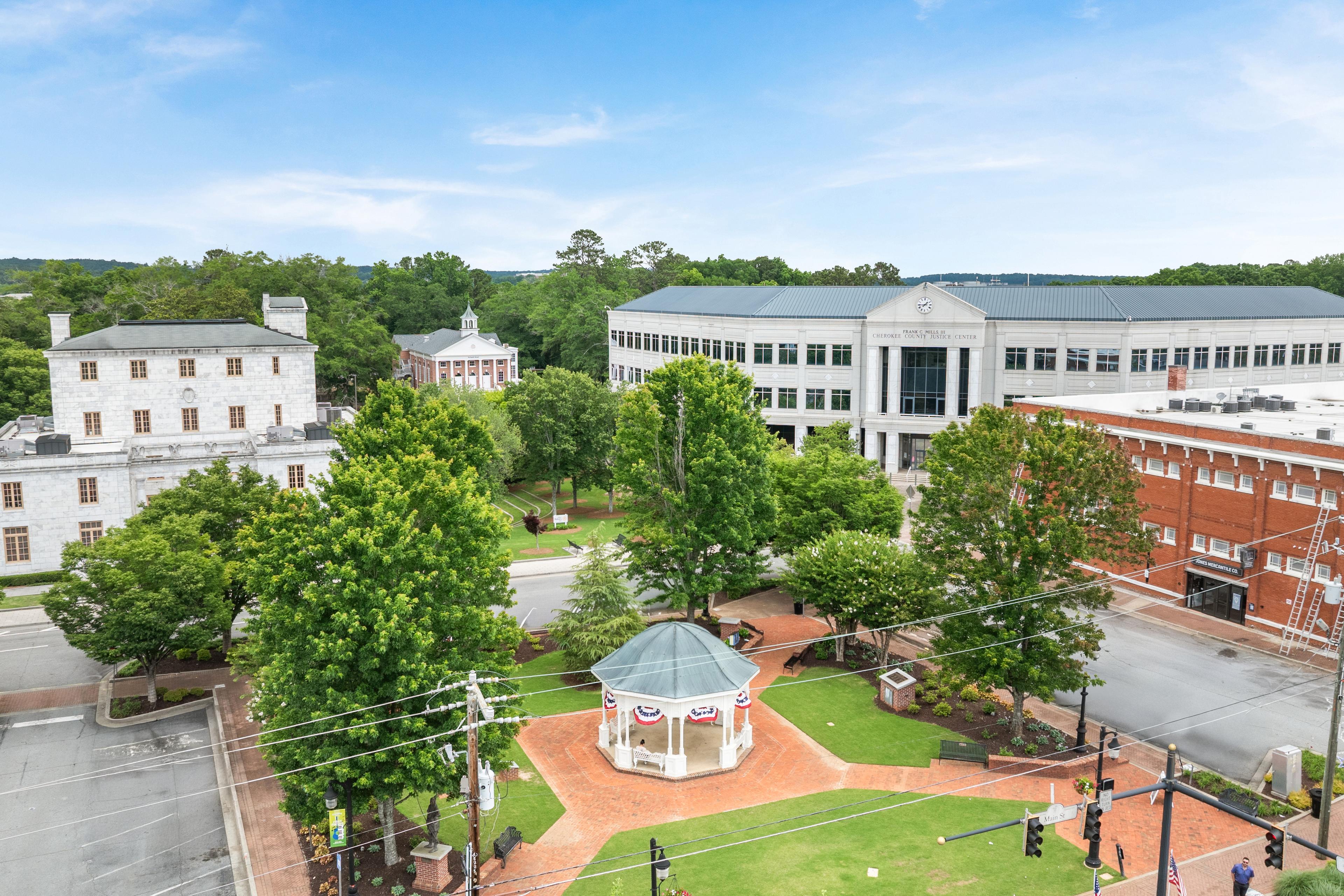 Aerial view of downtown Canton, Georgia, featuring the public park, gazebo, and local landmarks near The Bluffs community.