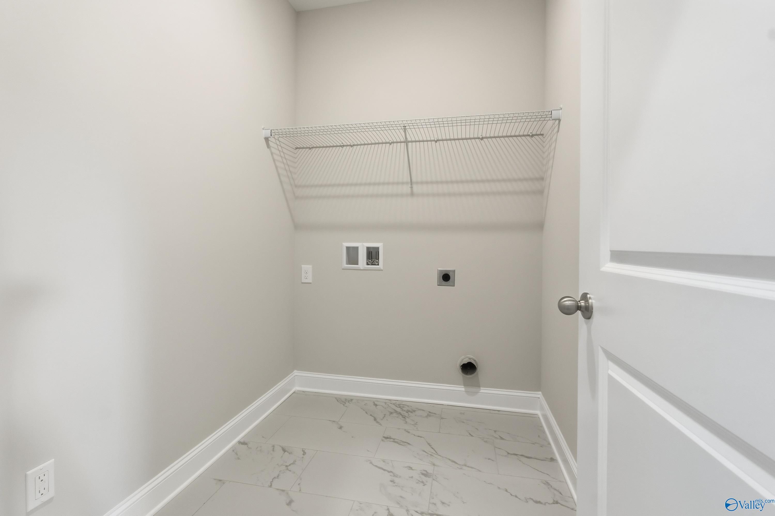 Spacious laundry room with wire shelving, washer/dryer hookups and marble-look flooring in Davidson Homes Montgomery B, Toney, AL