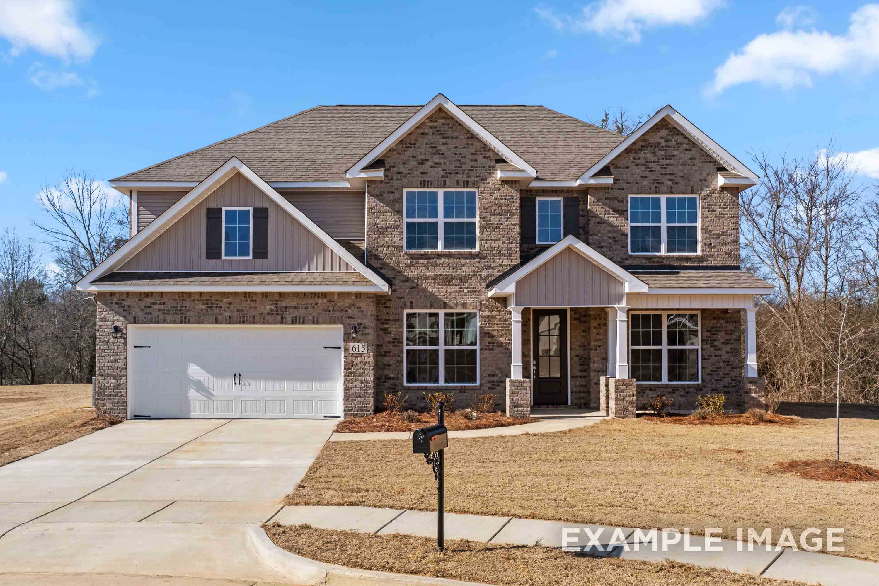 Two-story Madison B home elevation featuring brick and siding exterior, two-car garage, front porch, driveway in Meridianville
