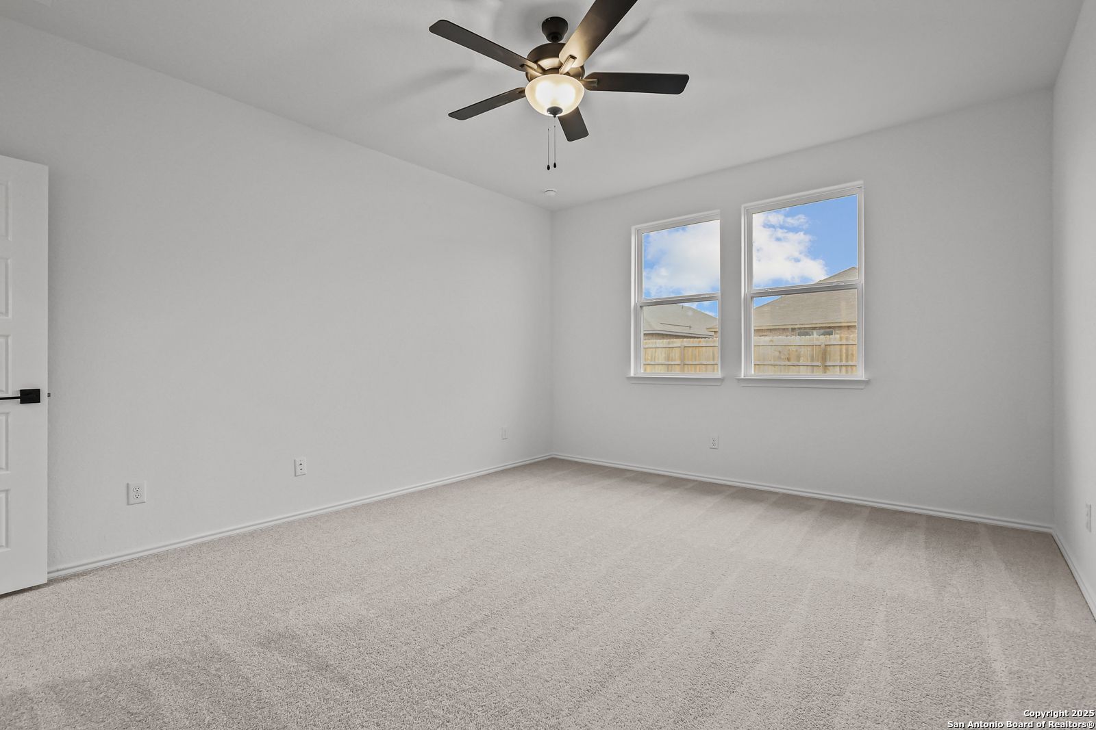 Bright secondary bedroom with ceiling fan, carpet flooring, and windows to backyard in Davidson Homes The Daphne J, Converse TX