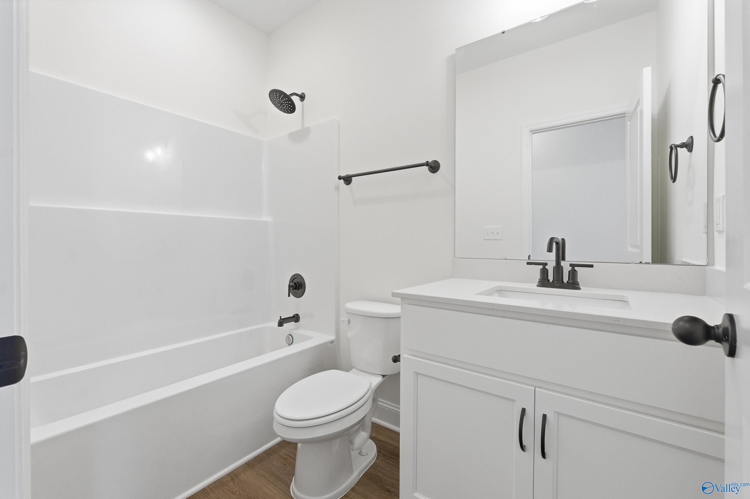 Bright white full bathroom with tub-shower combo, vanity sink, and toilet in Davidson Homes Rockford D, Hazel Green, Alabama