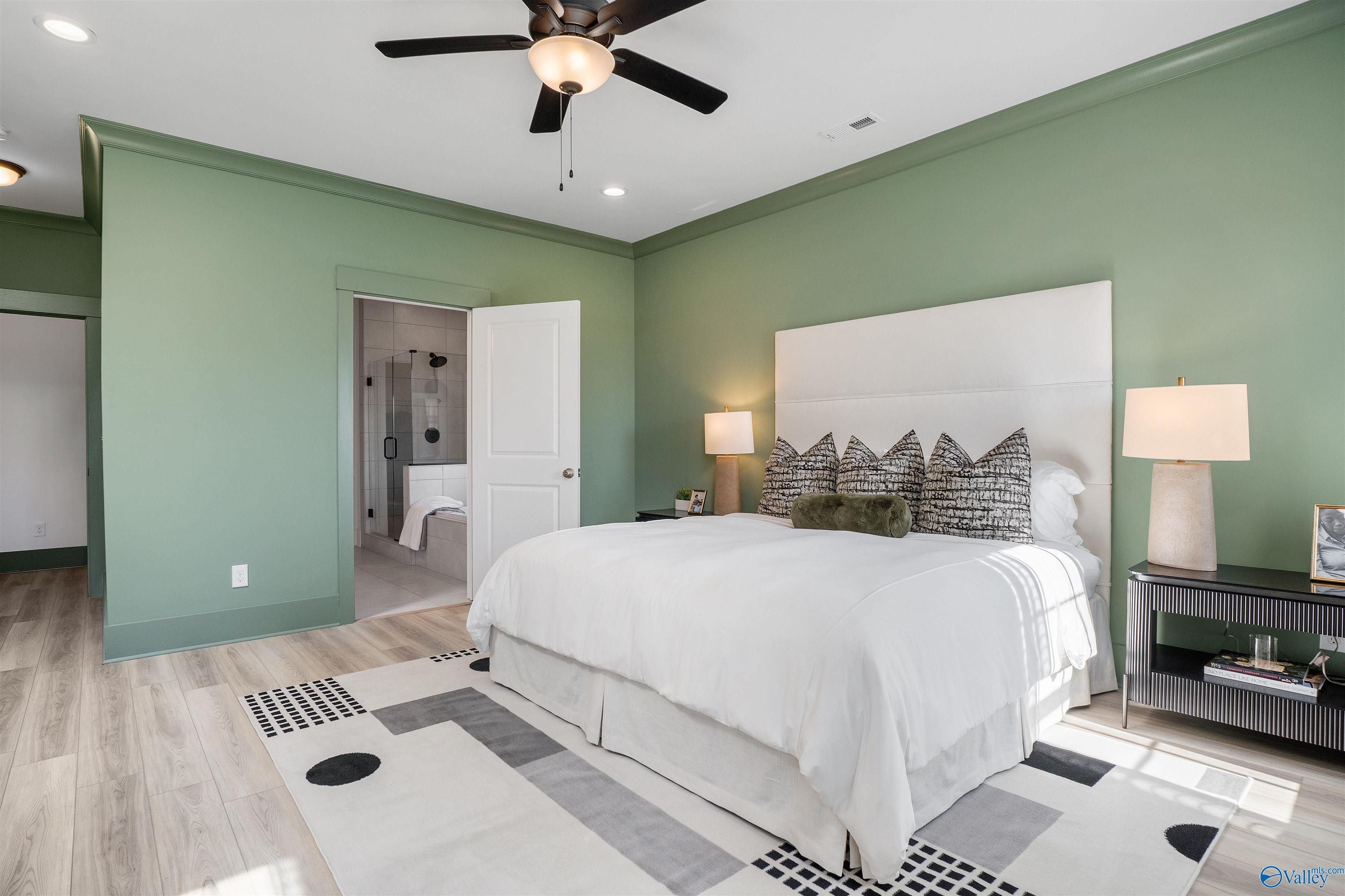 Elegant master bedroom with sage green walls, king bed, ceiling fan, en-suite bath in Davidson Homes The Rockford B, Madison, AL