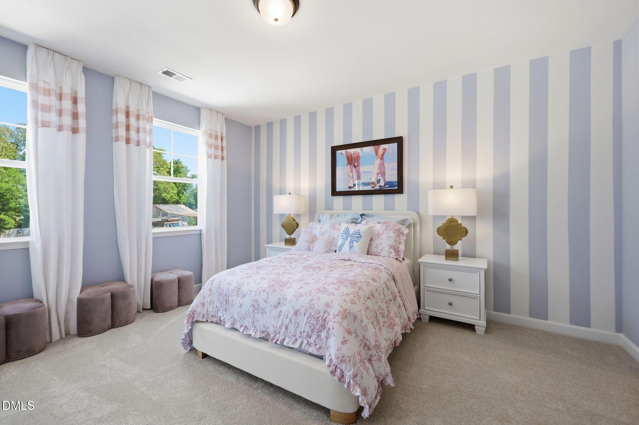 Cozy guest bedroom with striped accent wall in The Aspen B floor plan at Wendell Ridge, Wendell, North Carolina.