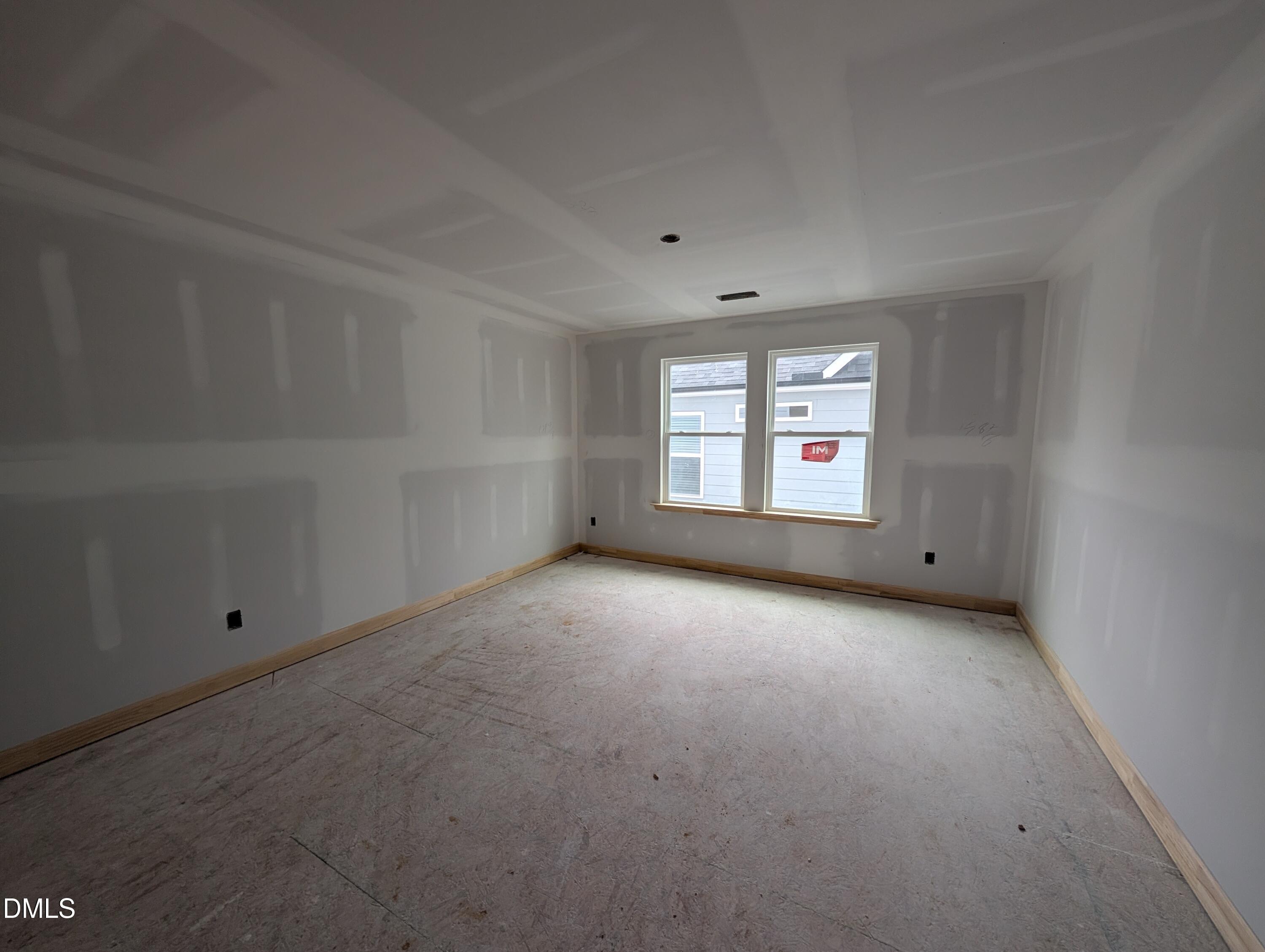 Unfinished bedroom with double windows and wood trim in Davidson Homes The Beech new construction home, Wendell Ridge, NC