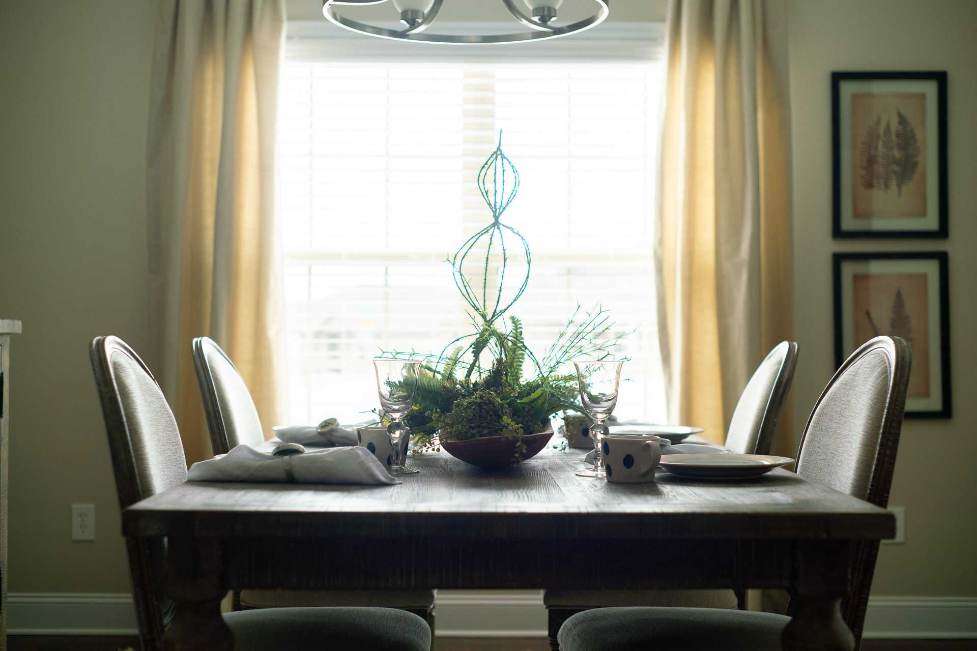 Spacious dining room at The Dairy at Oak Grove in South Huntsville AL with wooden table, upholstered chairs, and green plant centerpiece